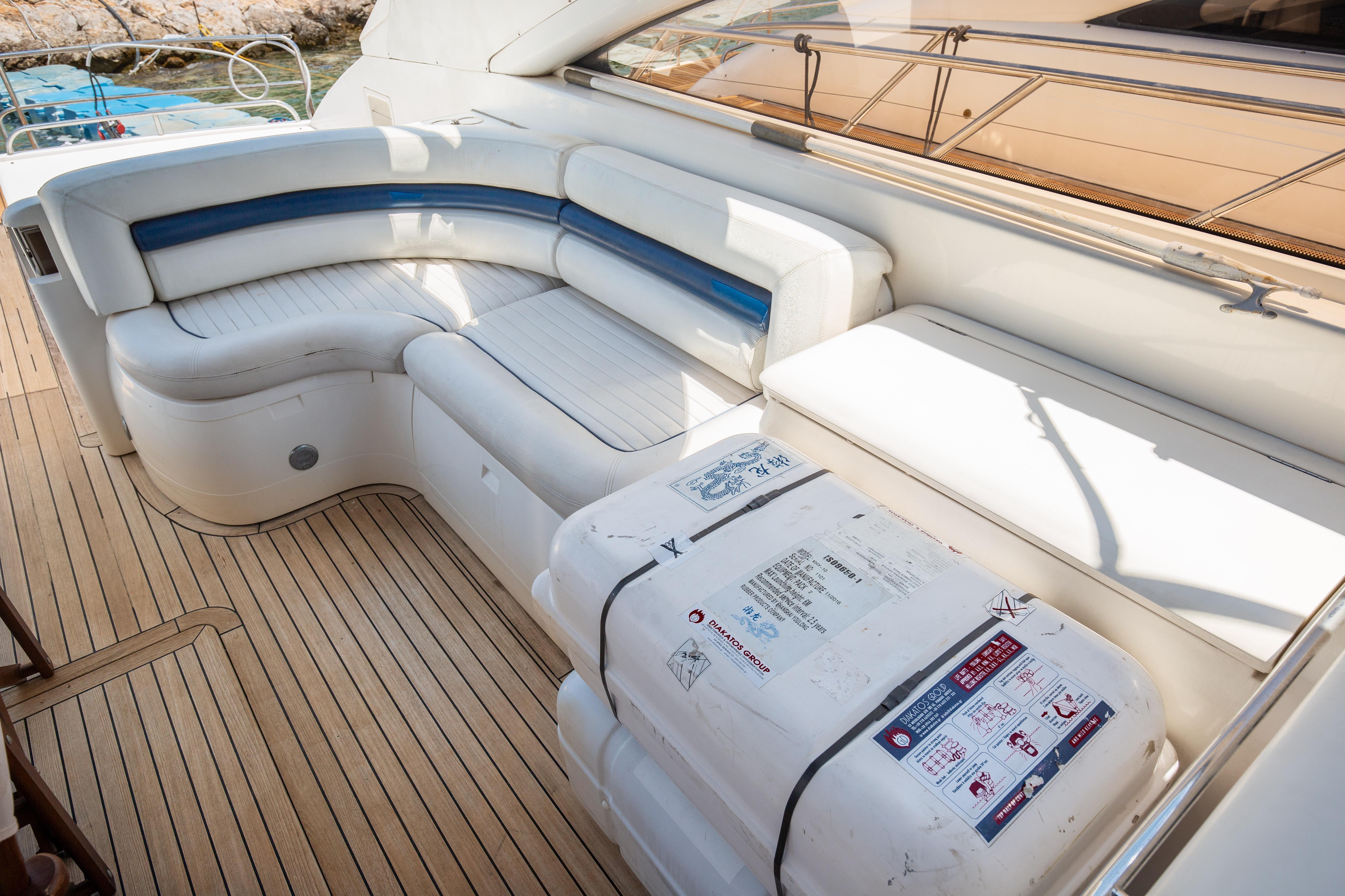 Luxurious seating area on 2004 Princess V65 yacht with wooden deck.