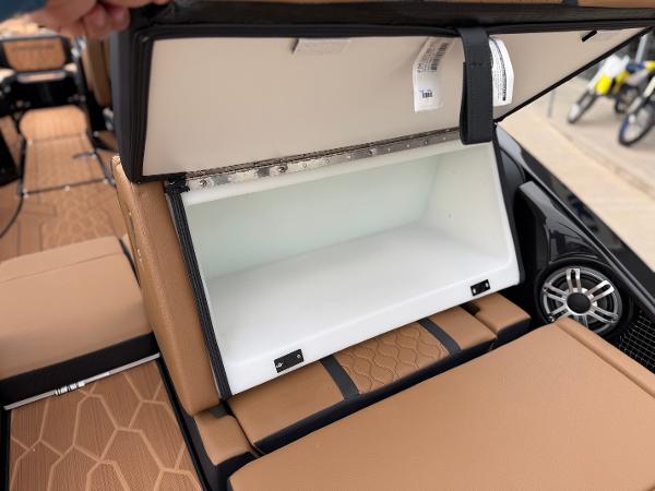 2025 Yamaha Boats 255XD storage compartment with tan seating and speaker detail.