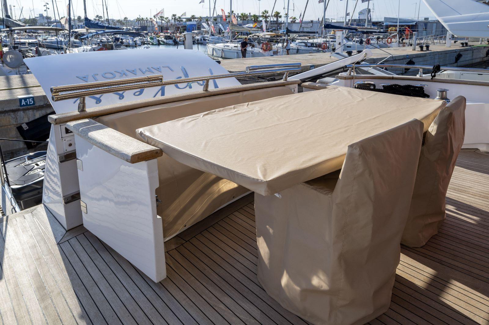 Luxury yacht Maiora 27, 2011 model, with covered outdoor dining area at marina.