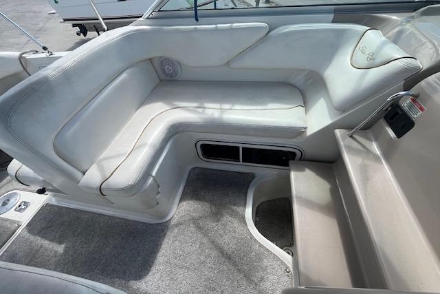 2003 Sea Ray 260 Sundancer boat interior with cushioned seating and carpeted flooring.