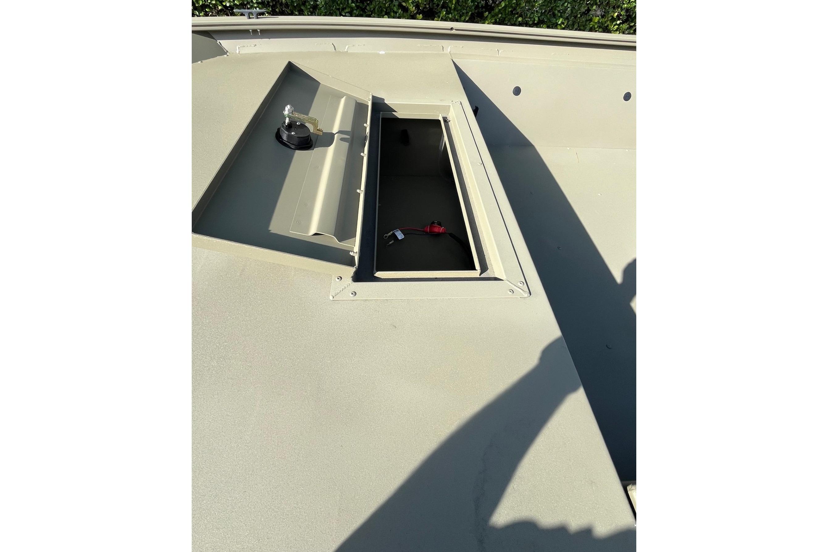 2026 Tracker Grizzly 1654 T Sportsman boat storage compartment, open lid, sunny day.