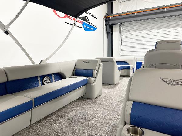 2025 Bennington 23LFBCSR pontoon boat interior with blue and gray seating in a showroom.