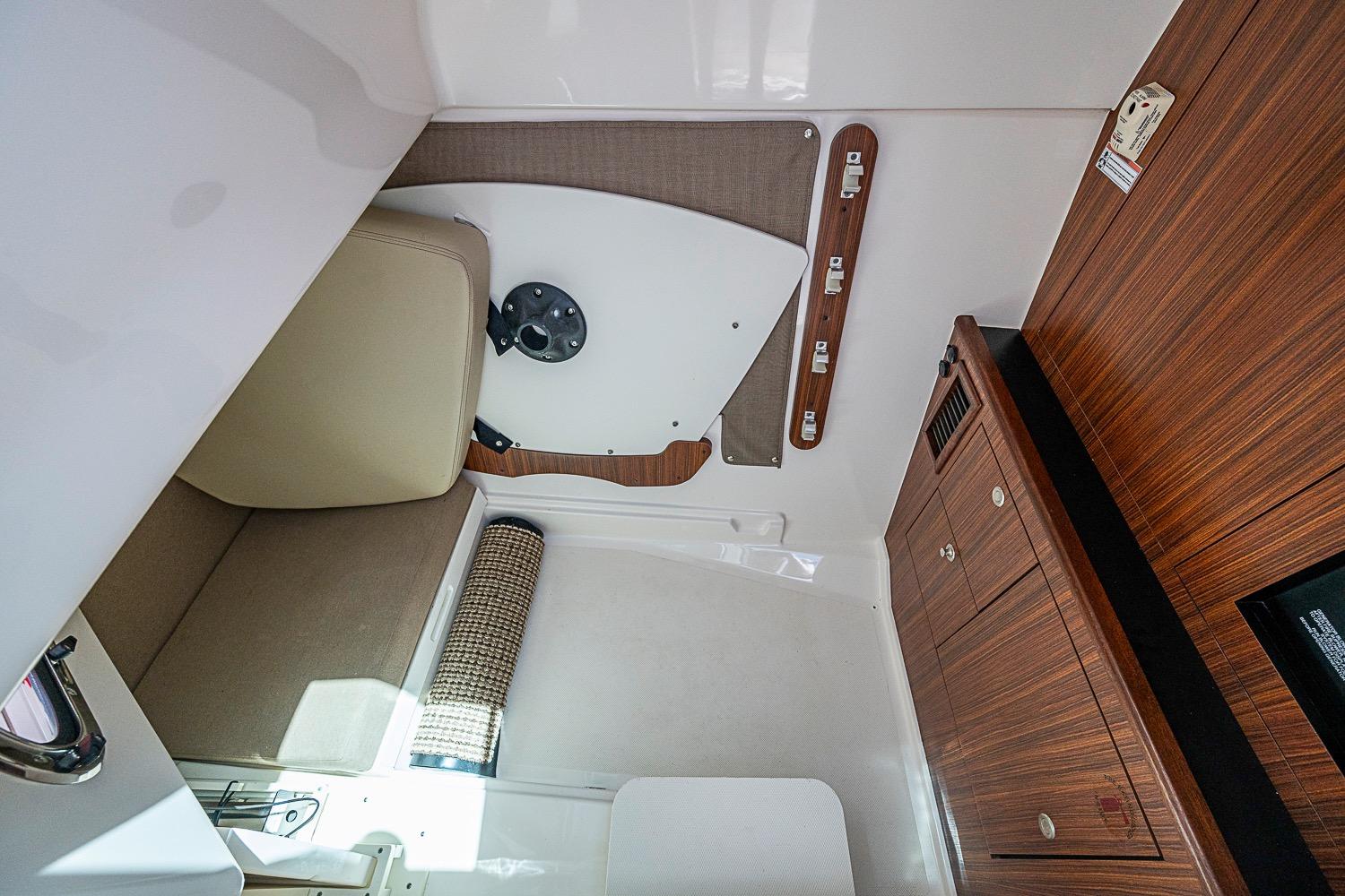 Interior cabin of 2016 Pursuit DC 325 Dual Console boat with wood finish and seating.