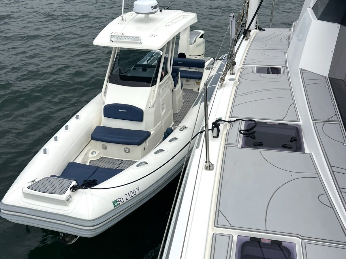 A 2022 Brig Eagle 8 is docked beside a larger boat on the water.