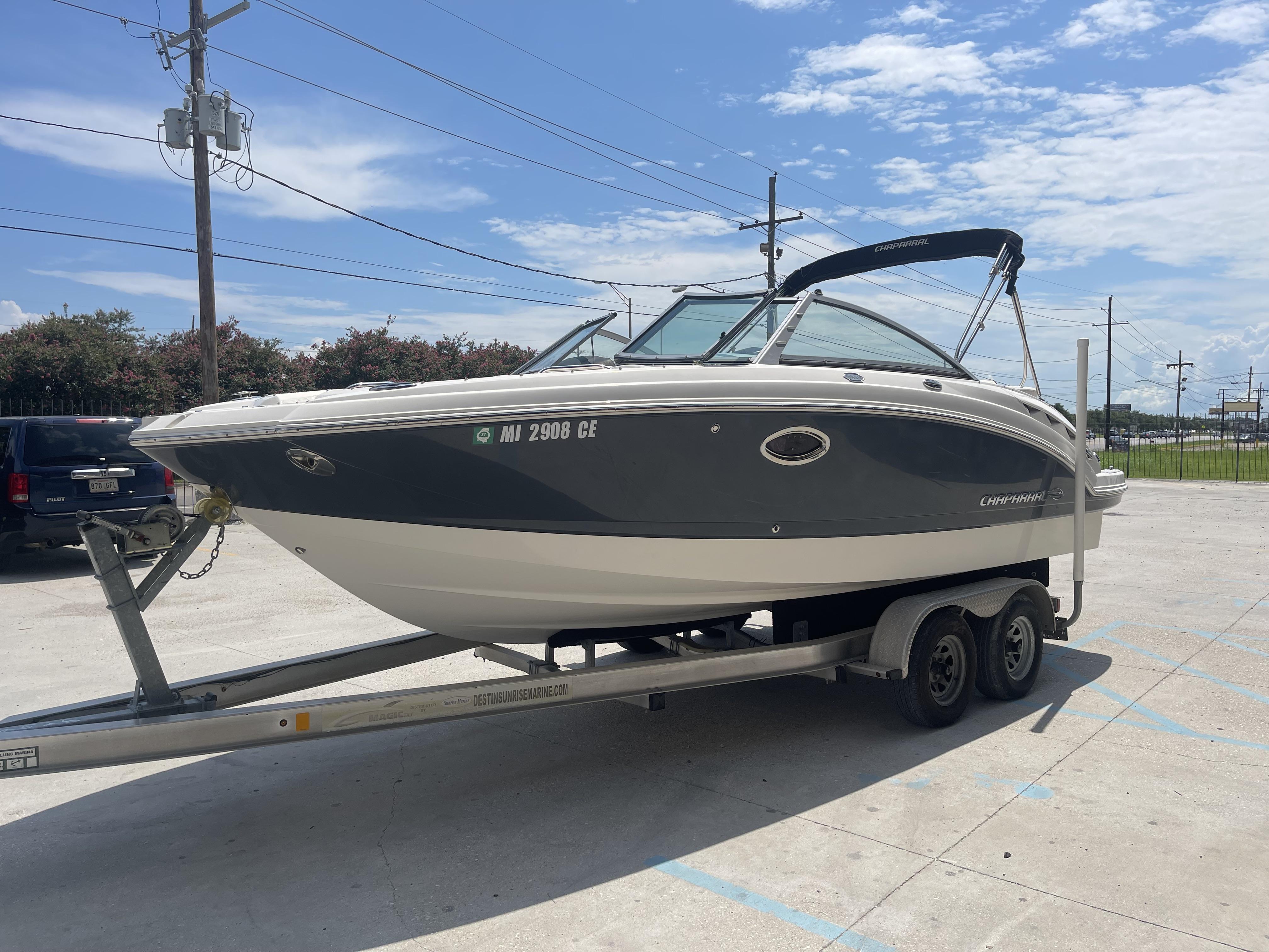2014 Chaparral Sunesta 224 boat on trailer in sunny parking lot.