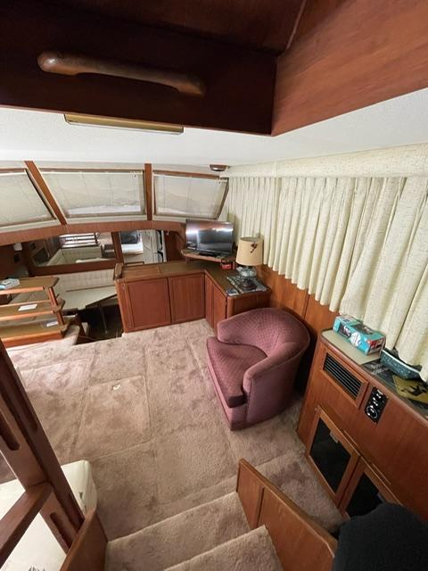 Interior of a 1984 Uniflite Double Cabin yacht with cozy seating and wooden cabinetry.