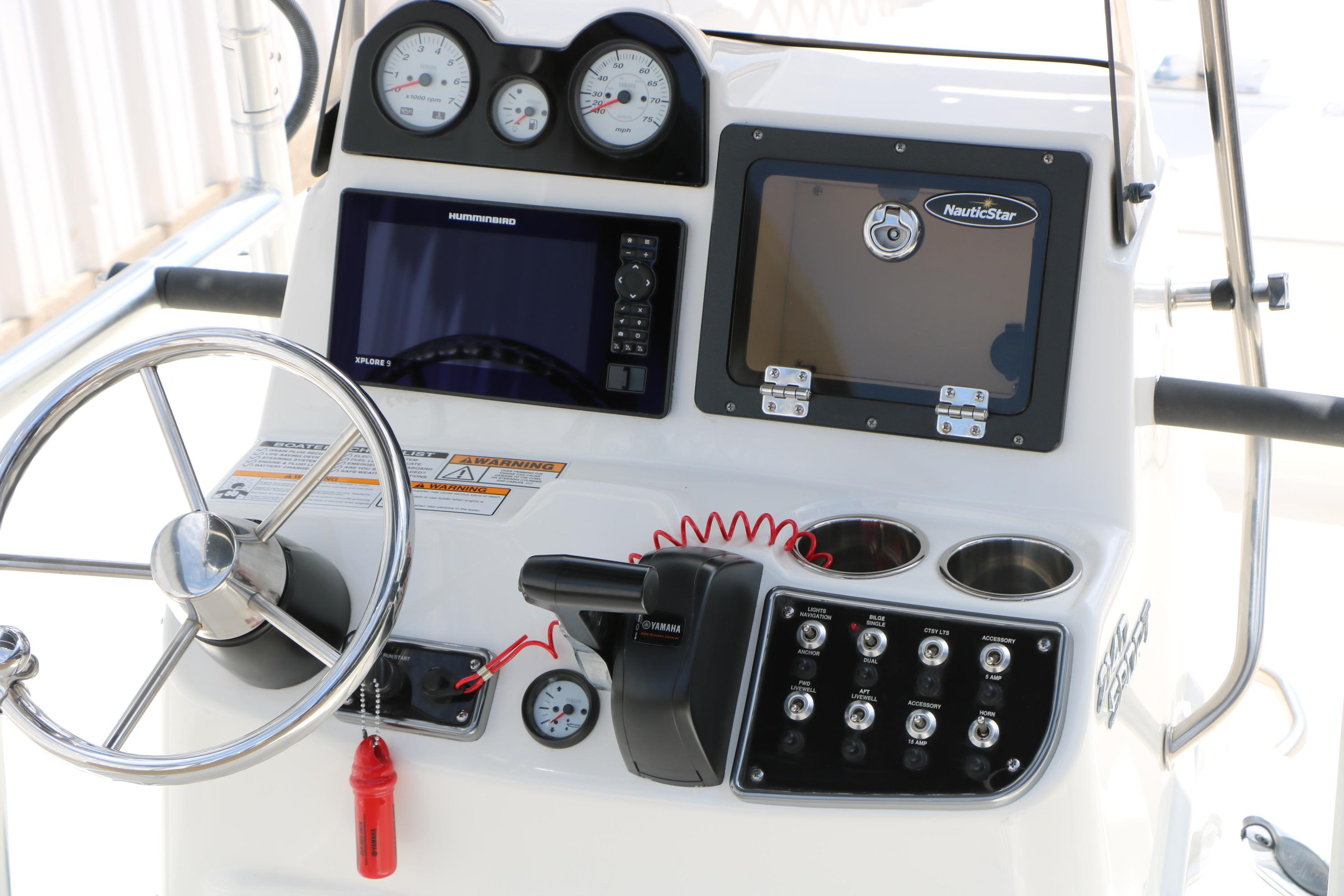 Control panel of 2020 NauticStar 2140 Sport boat with steering wheel and gauges.