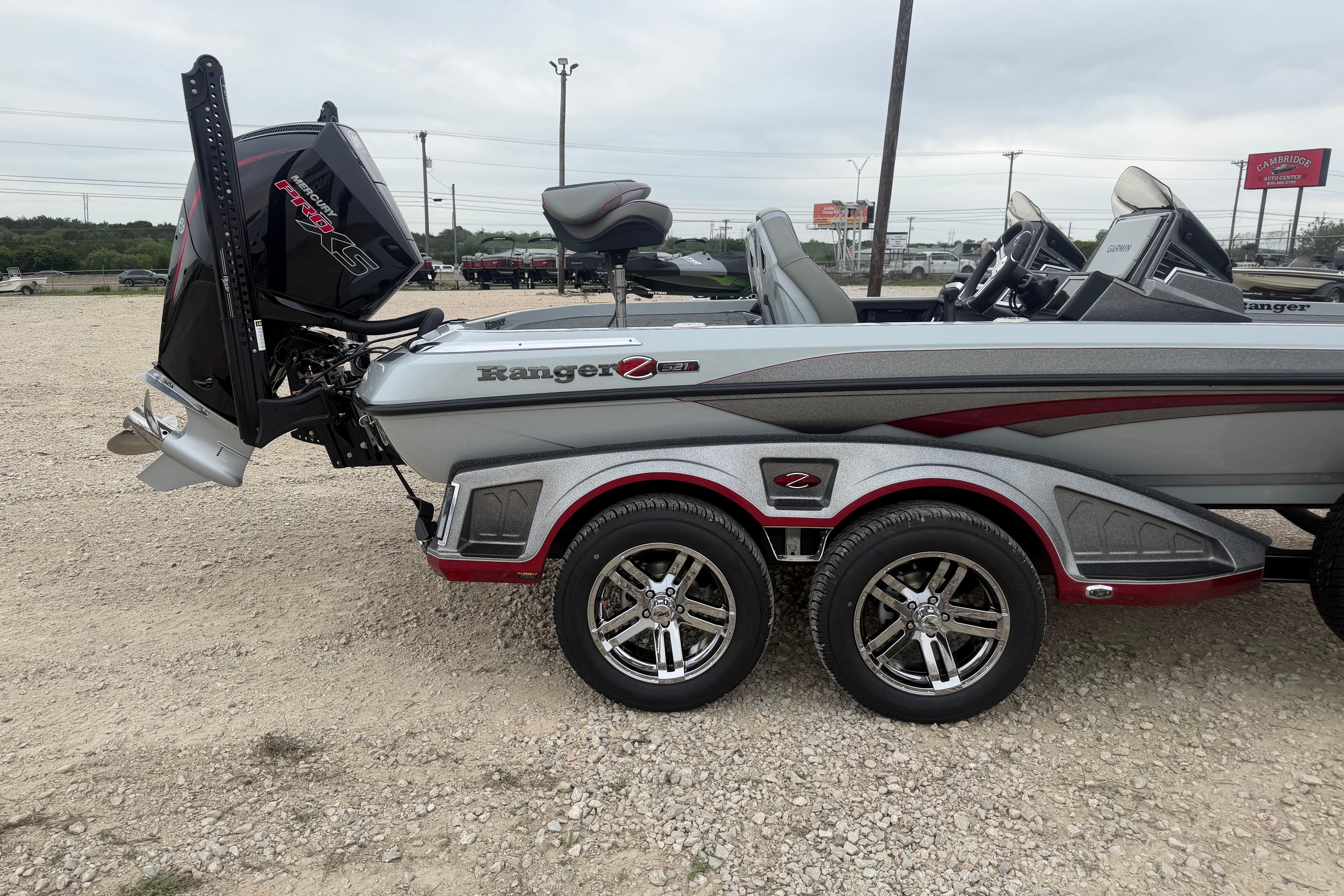 2026 Ranger Z521R Cup-Equipped boat with dual-axle trailer, parked on gravel.