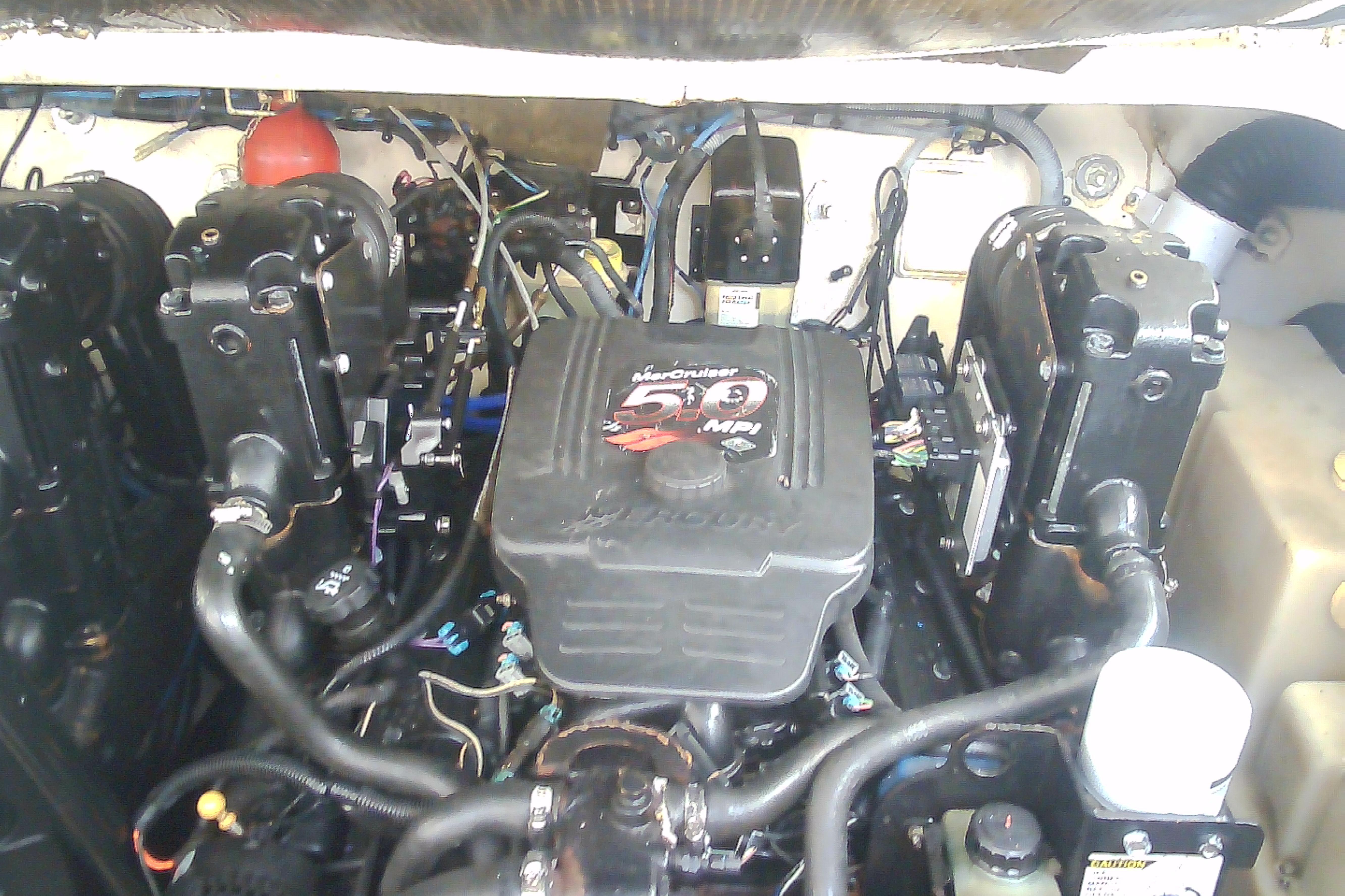 Engine compartment of a 2005 Sea Ray 300 Sundancer boat, featuring a MerCruiser 5.0 MPI engine.
