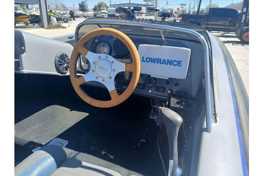 1994 Gambler 21 boat cockpit with wooden steering wheel and Lowrance navigation system.