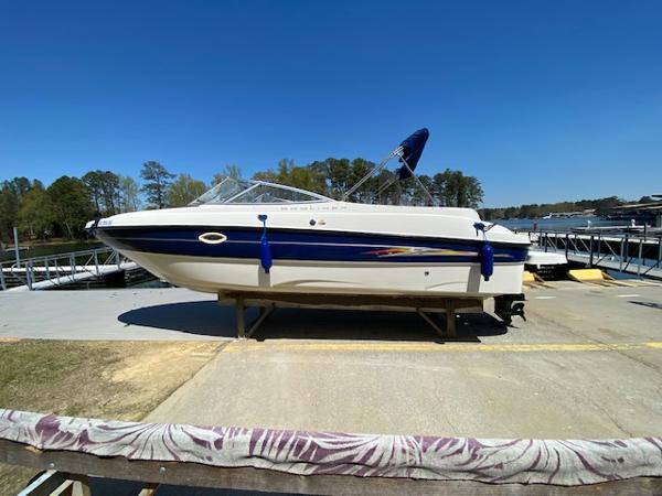 2005 Bayliner 249 SD boat on display at a marina under clear blue skies.