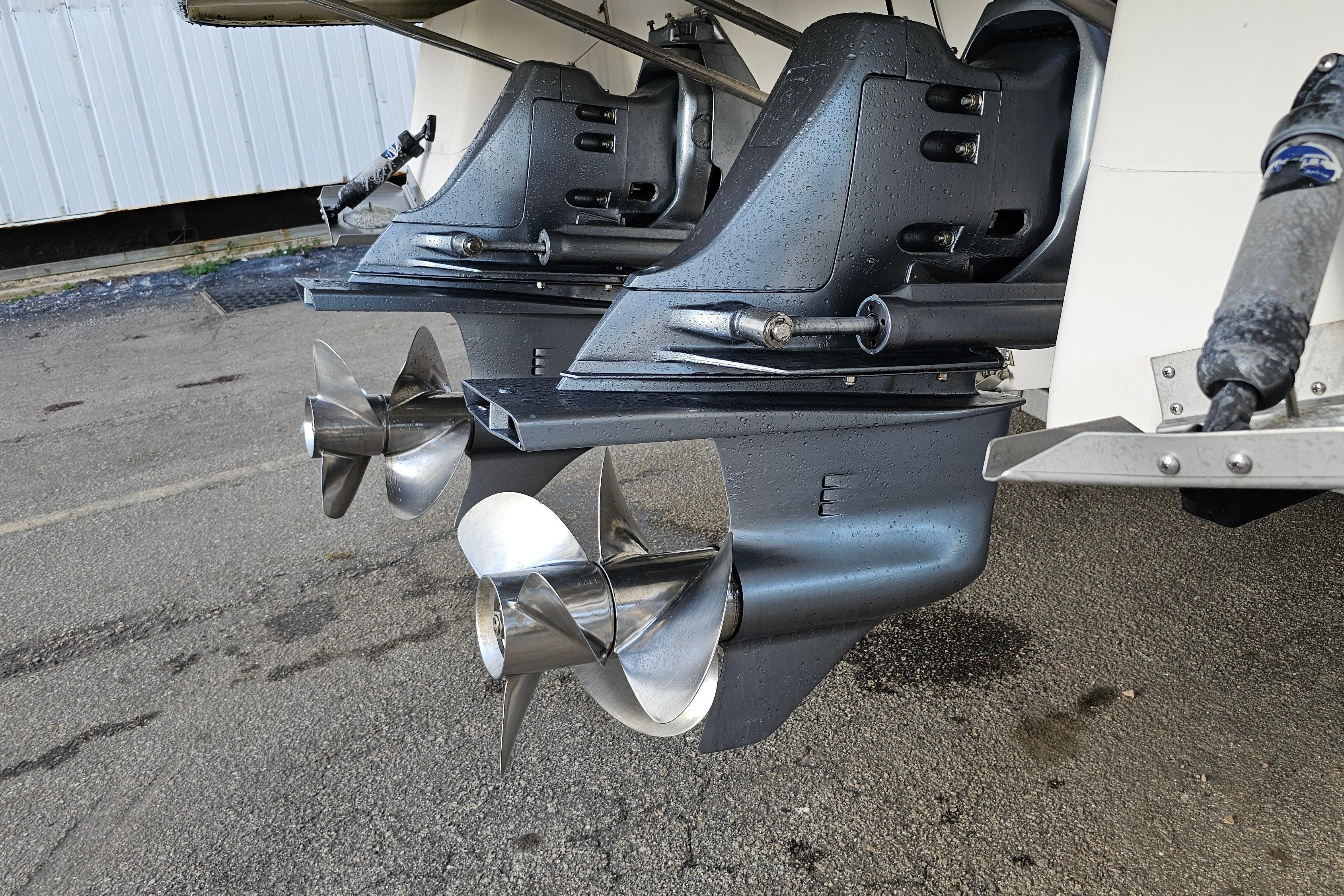2005 Regal 3060 Window Express boat propellers on a wet pavement background.