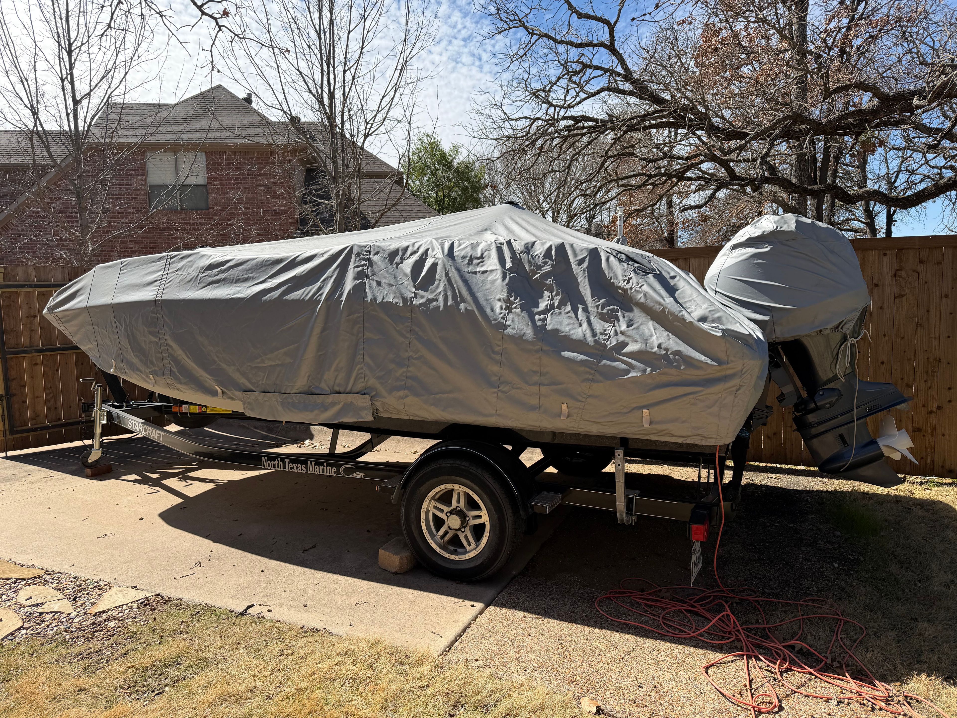 A 2023 Starcraft SVX 171 OB boat, covered and parked on a trailer outdoors.