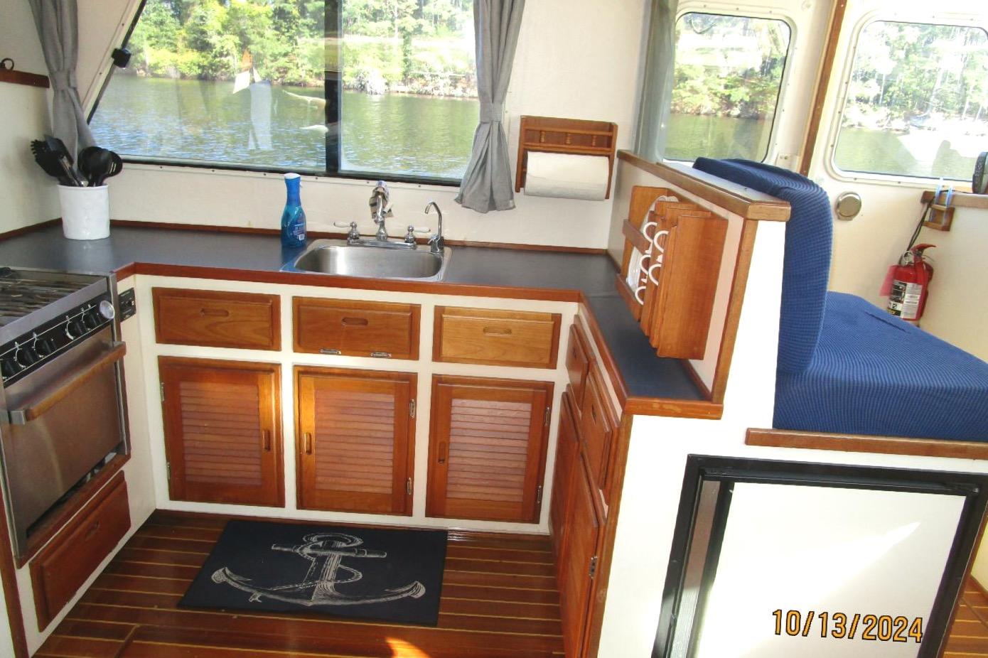 Interior of 1997 Rosborough Trawler kitchen with wooden cabinets and nautical decor.