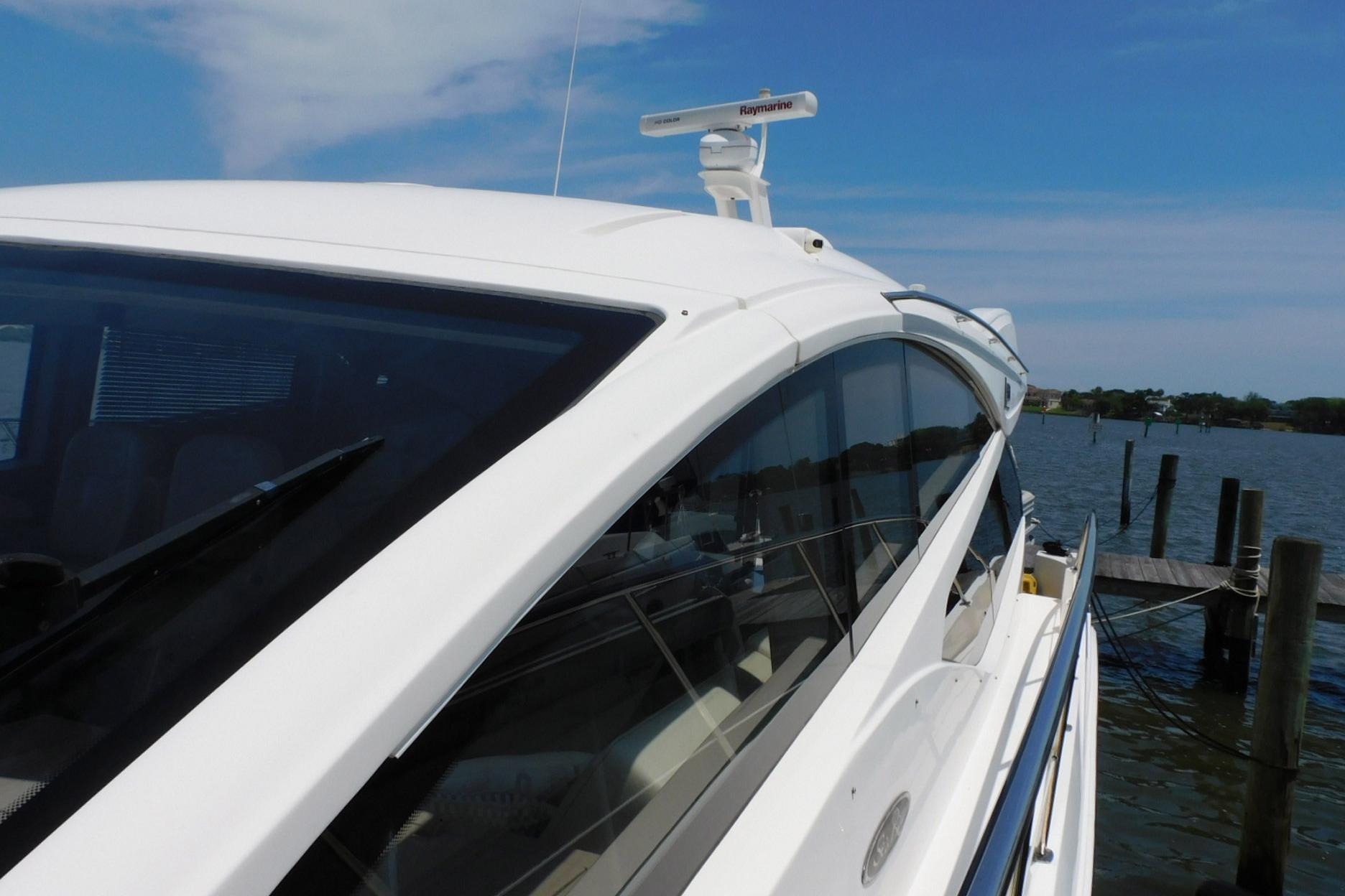 2019 Sea Ray L550 yacht docked by the water on a sunny day.