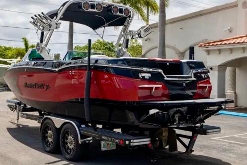 2019 MasterCraft XStar boat on trailer, red and black design, parked outdoors.