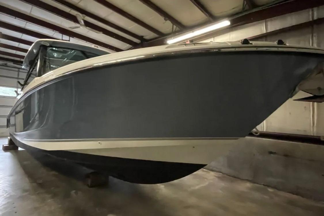 2025 Boston Whaler 330 Vantage boat in storage, showcasing sleek hull design.