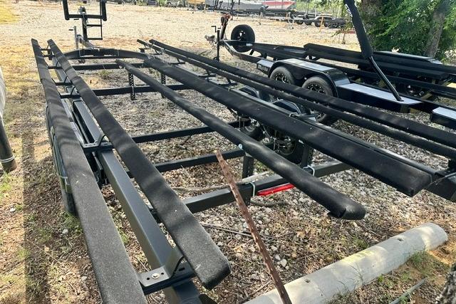 Trailer for 2021 Bennington L Bowrider 25 Quad Bench, parked on gravel.