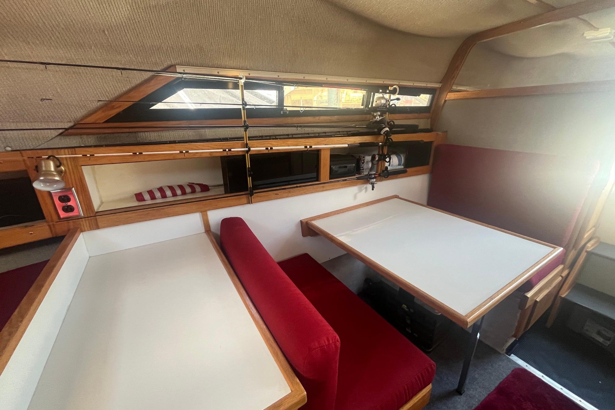 Interior of 1988 Seafox 29 Flybridge with red seating and wooden accents.