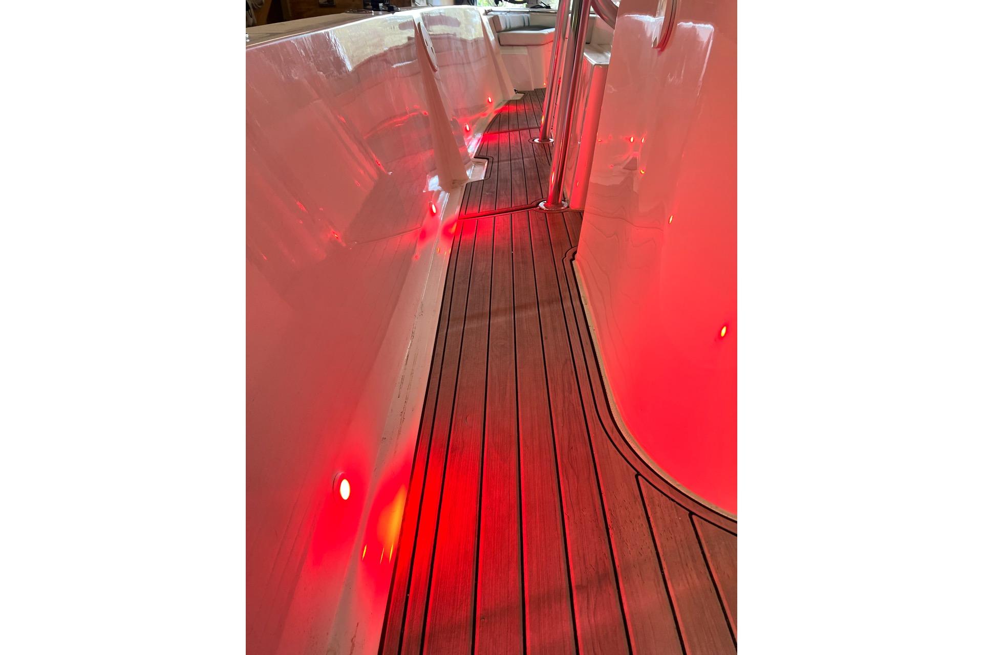 Custom Infusion 34 CC 2021 boat interior with red LED lighting and wooden flooring.