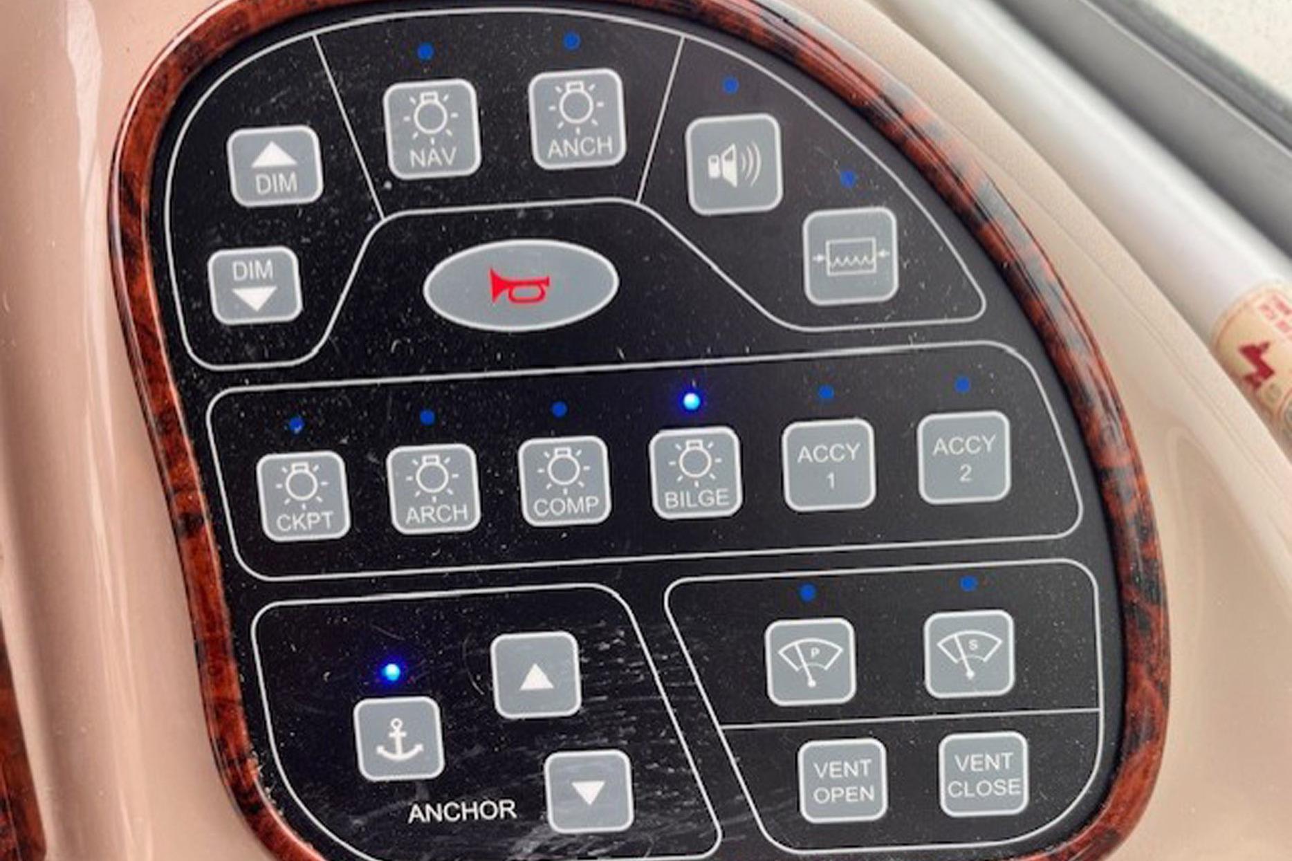 Control panel of a 2003 Sea Ray 300 Sundancer boat with various function buttons.