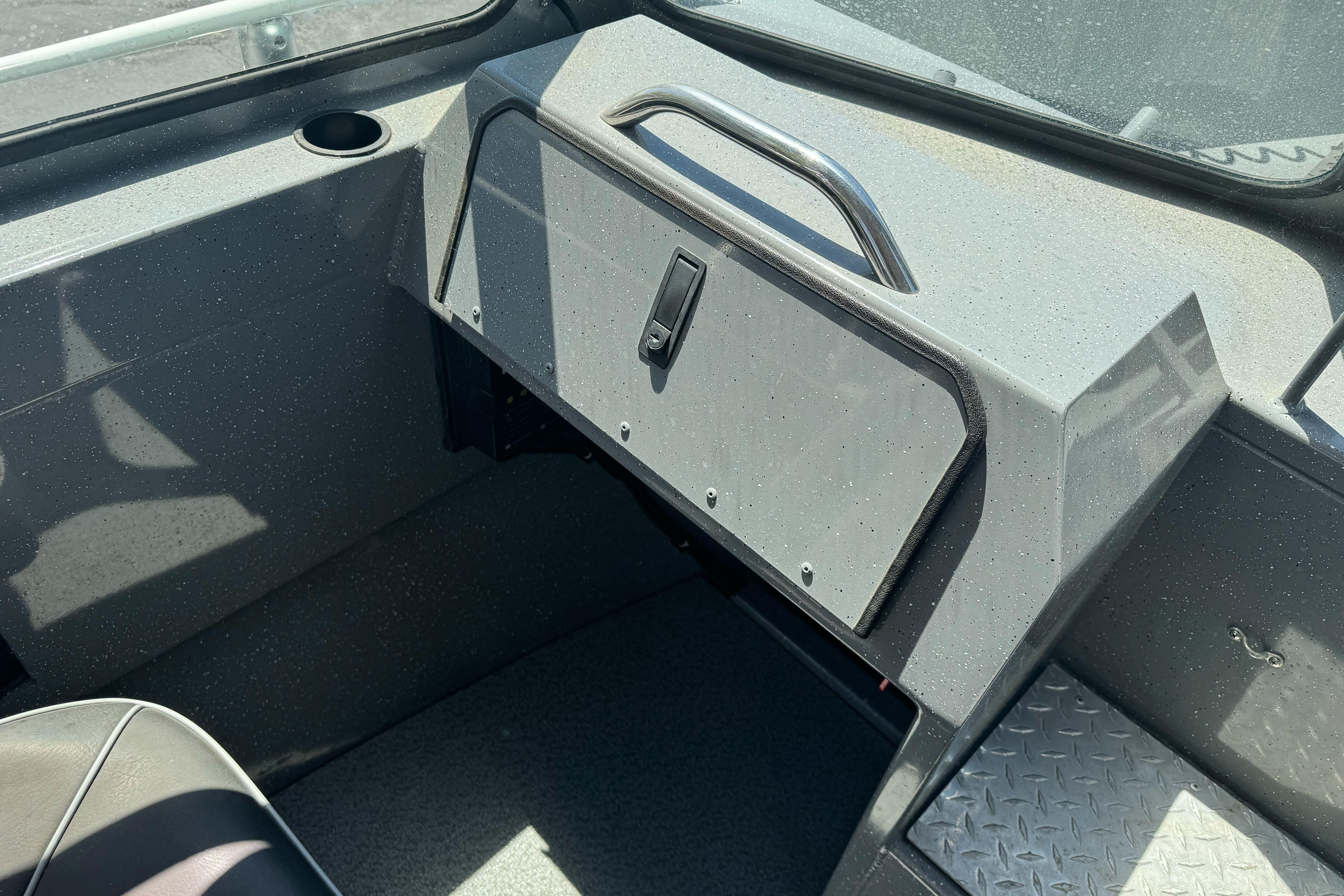 Interior of a 2014 River Hawk 19 GB boat, featuring a glove compartment and seating area.