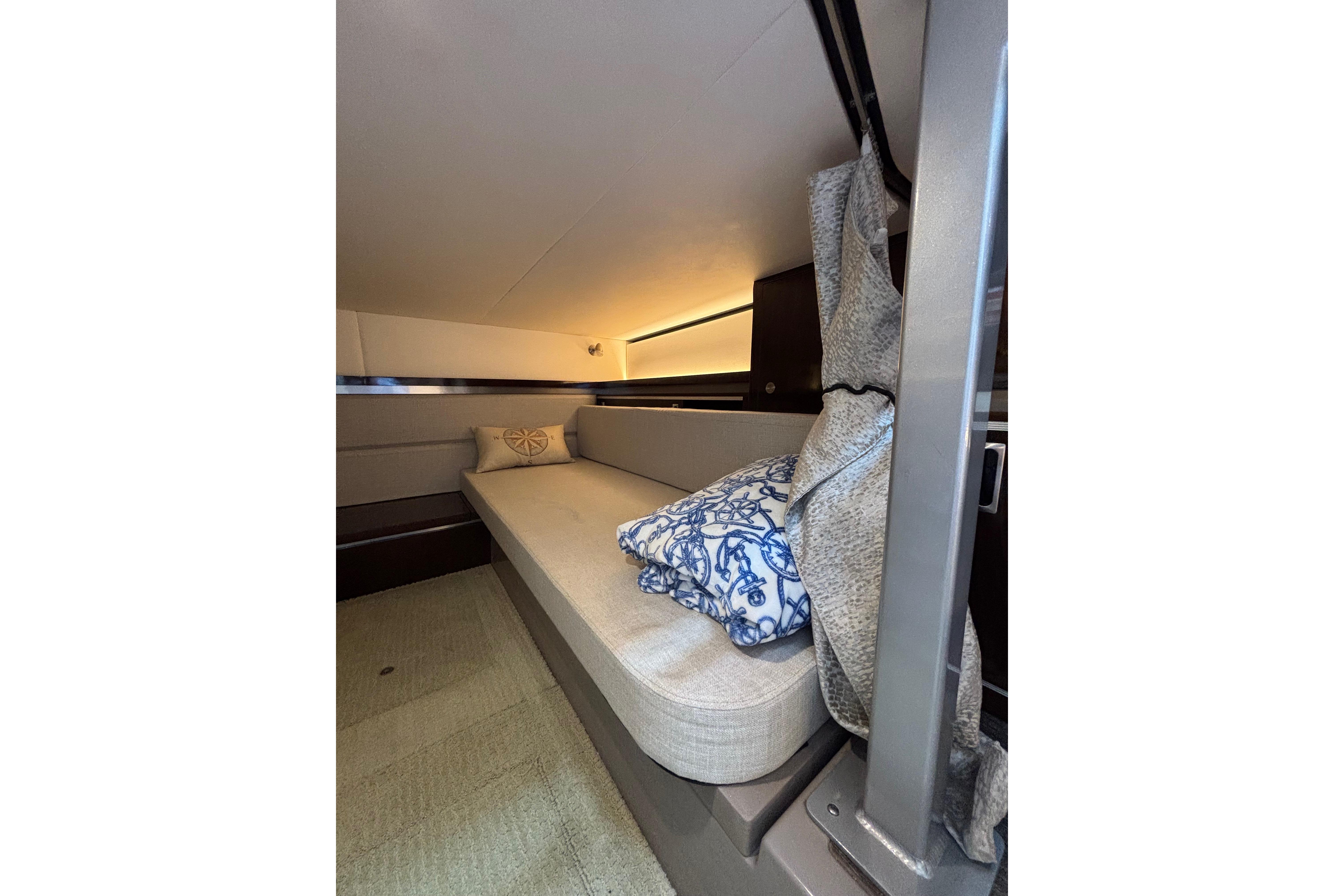2021 Sea Ray Sundancer 320 Outboard cabin interior with cozy seating and decorative pillows.