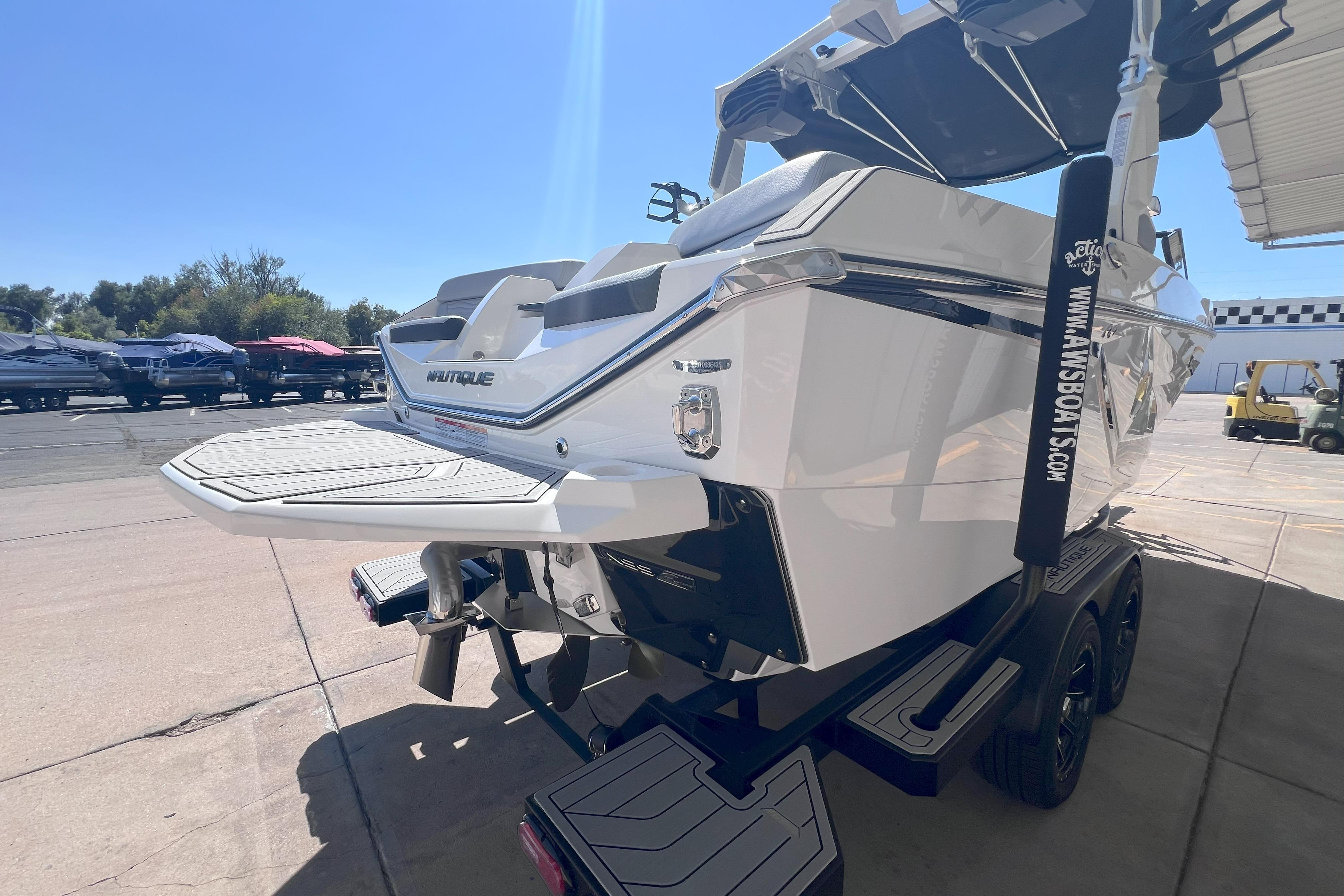 2025 Nautique Super Air Nautique G21 boat on trailer, rear view in sunny outdoor setting.