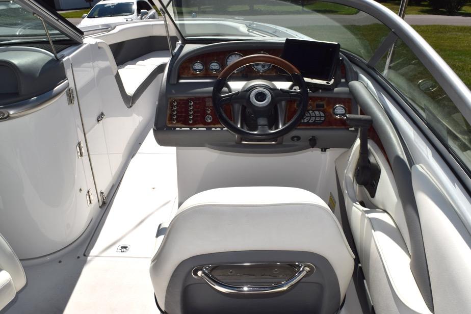 Interior view of a 2006 Cobalt 240 boat cockpit with steering wheel and dashboard controls.