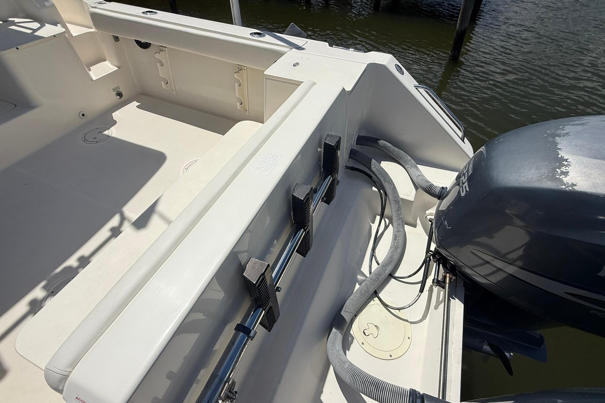 2003 Pursuit 2870 Walkaround boat deck with outboard motor and clean interior.
