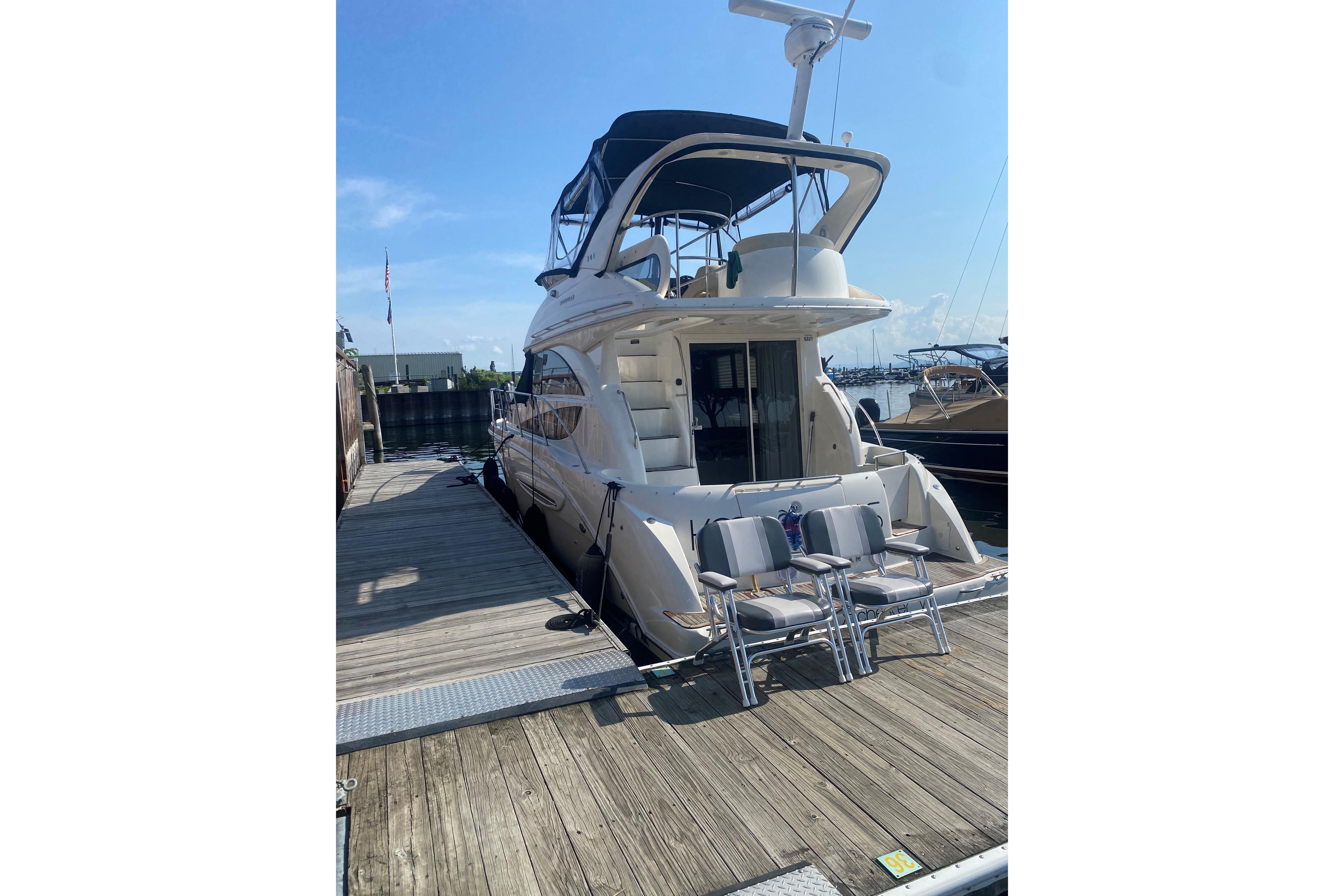 2012 Meridian 341 Sedan yacht docked at marina under clear blue sky.