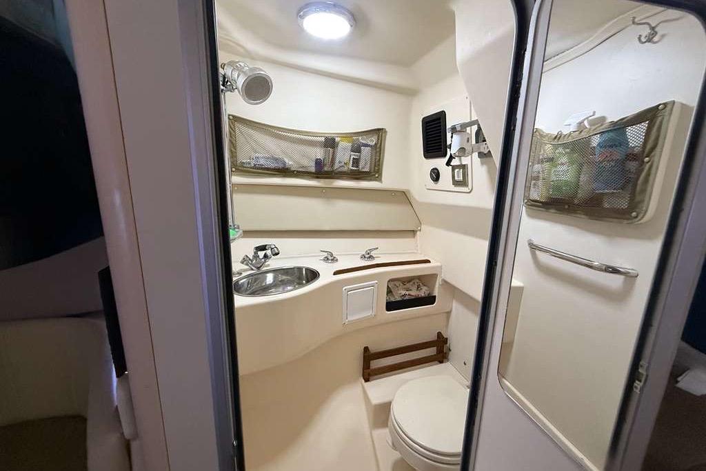 2007 Grady-White Express 305 boat bathroom with sink, toilet, and storage compartments.