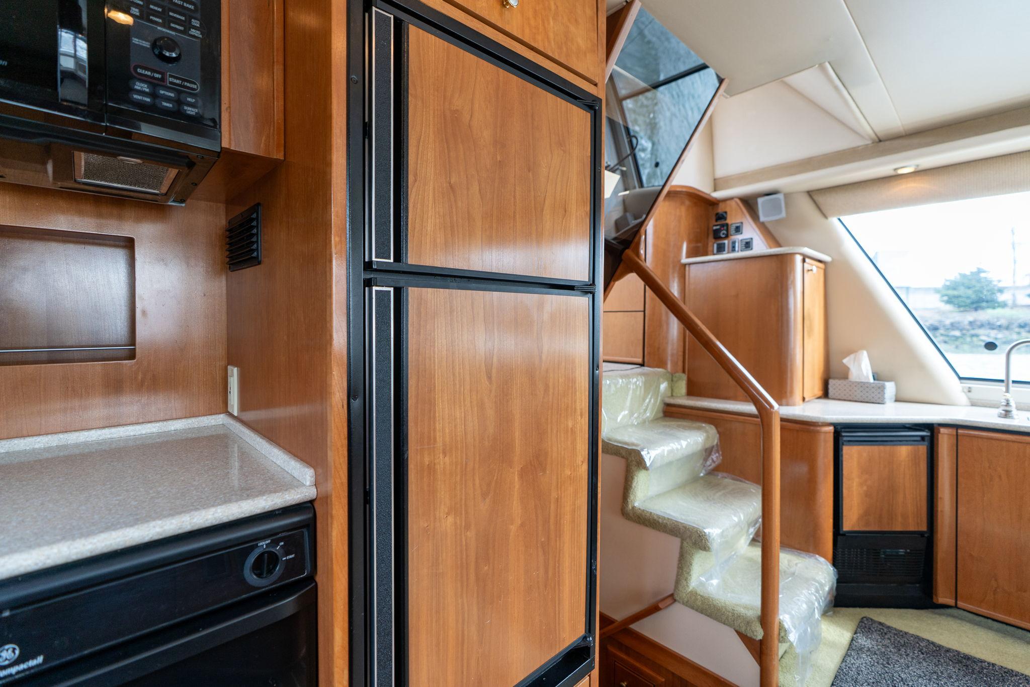 Interior of 2003 Meridian 490 Pilothouse with wooden cabinetry and staircase.