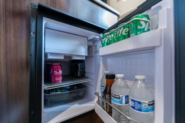 Mini fridge stocked with drinks inside a 2016 Regal 28 Express boat.