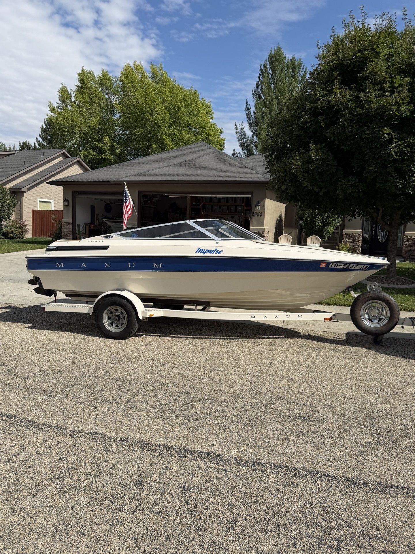 A 1991 Maxum 1800 SR boat on a trailer in a residential area.