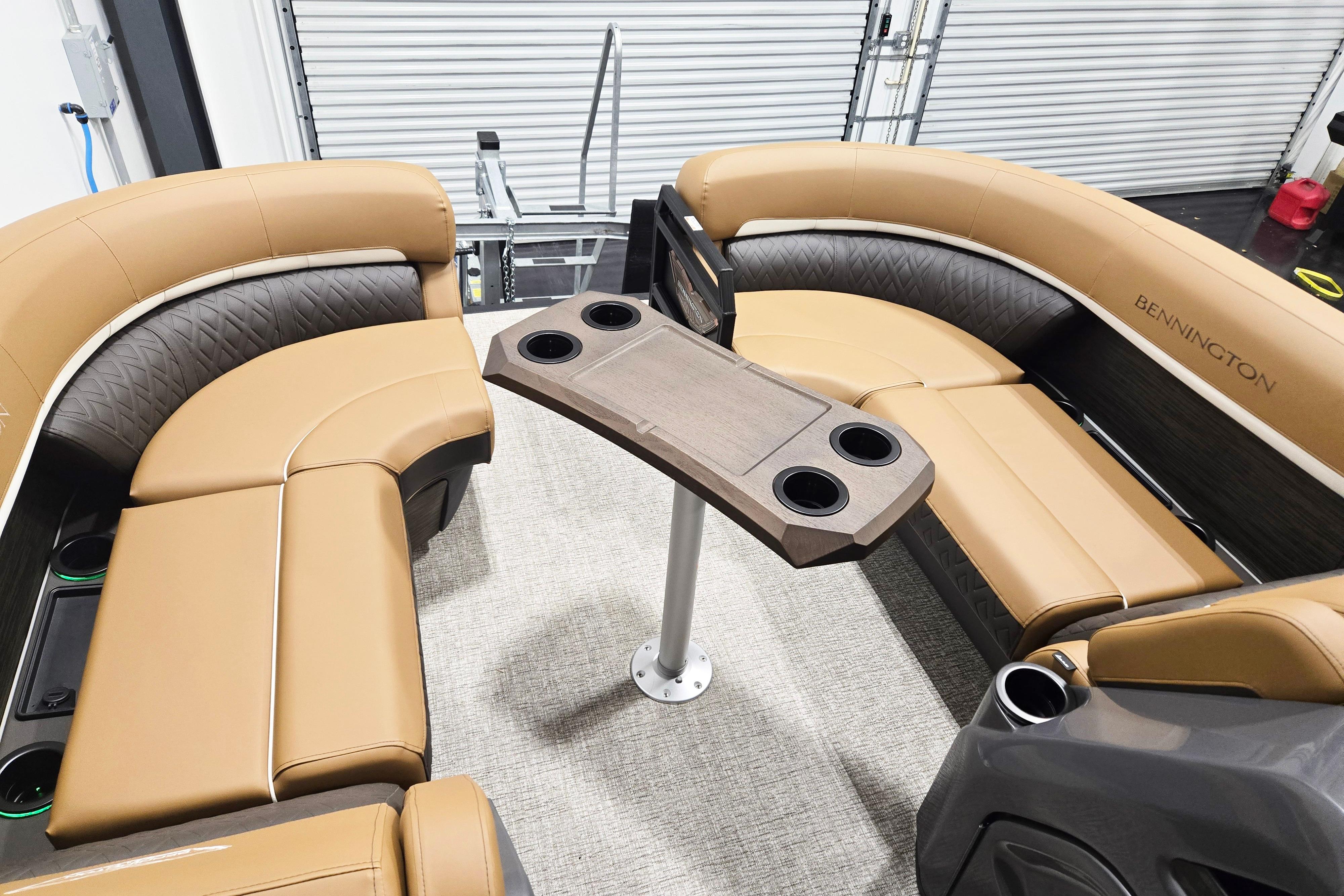 Luxurious seating area on 2026 Bennington 22 M Swingback pontoon boat with cup holders.