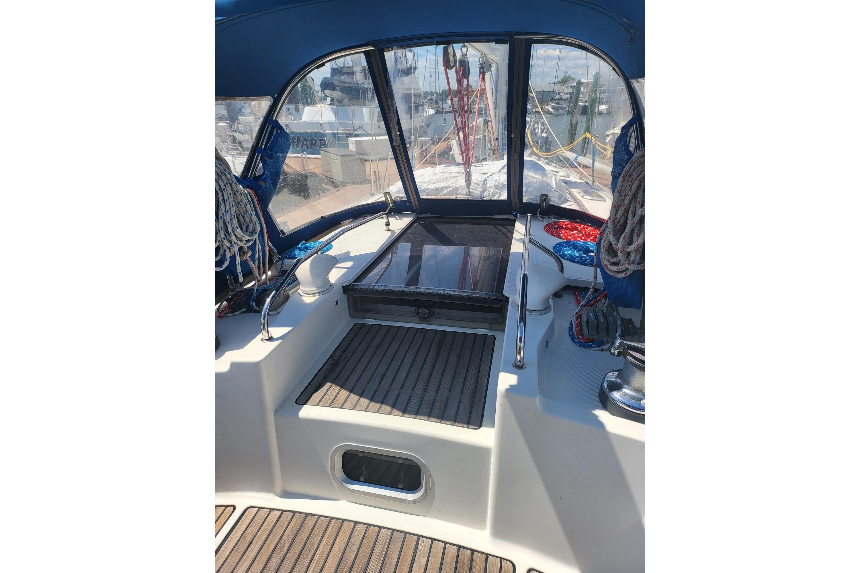 Cockpit view of 1993 Jeanneau Sun Odyssey 42.1 sailboat with blue canopy and ropes.