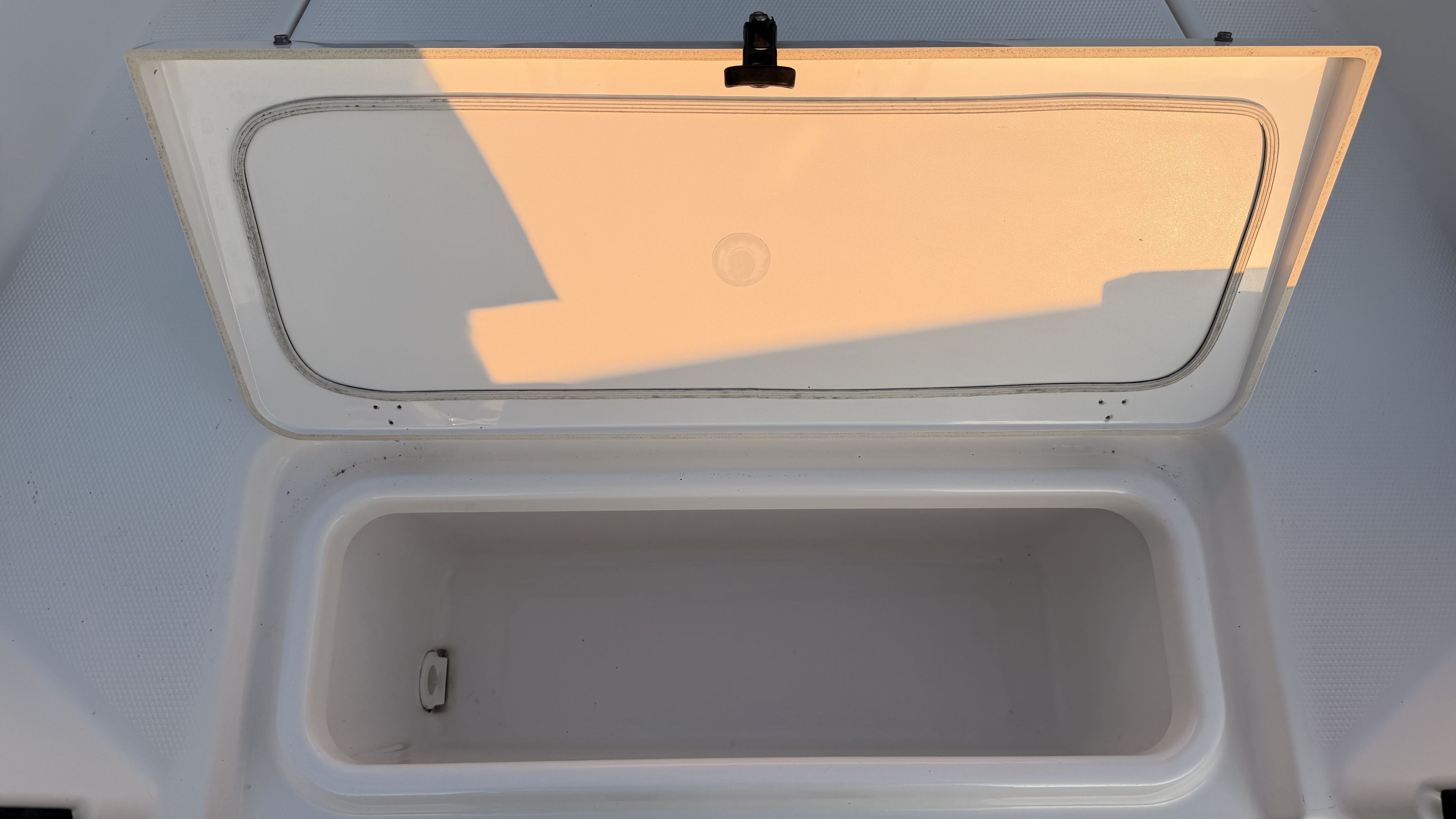 An open storage compartment on a 2019 Yamaha 190 FSH Sport boat.