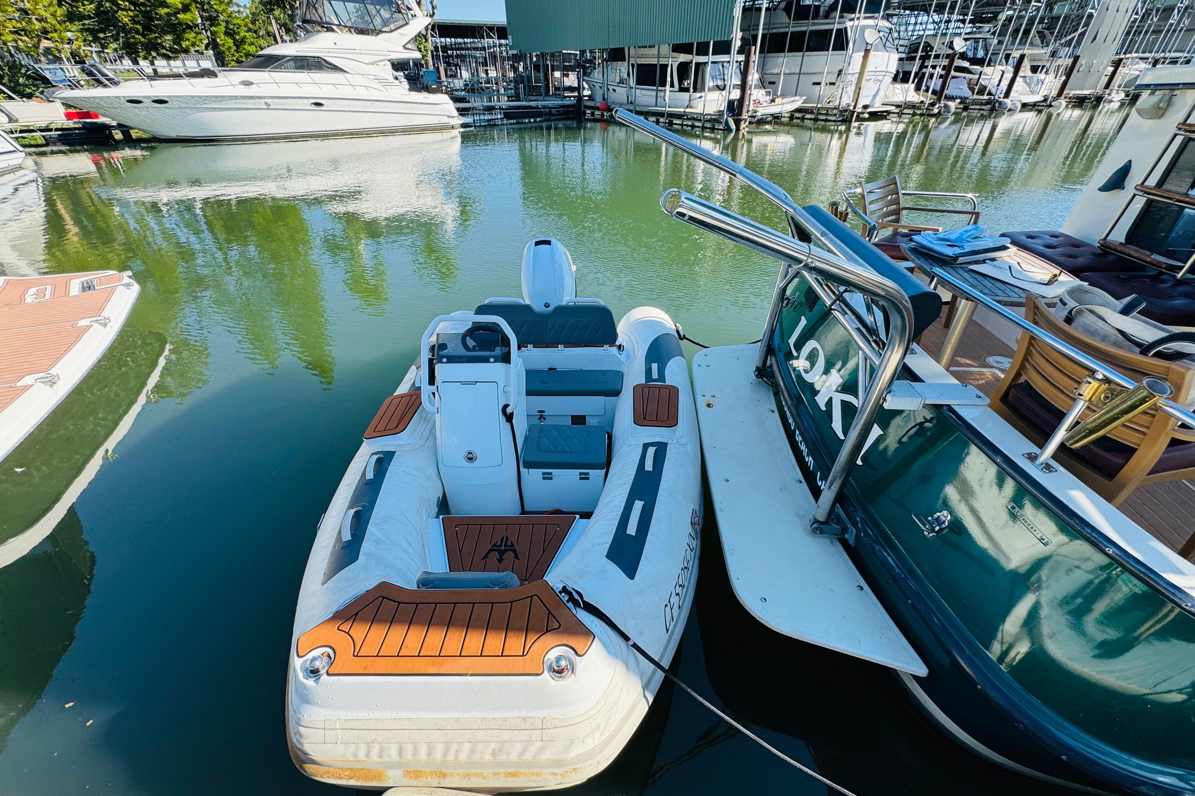 Nordic Tug 32 (1996) docked beside inflatable boat in marina setting.