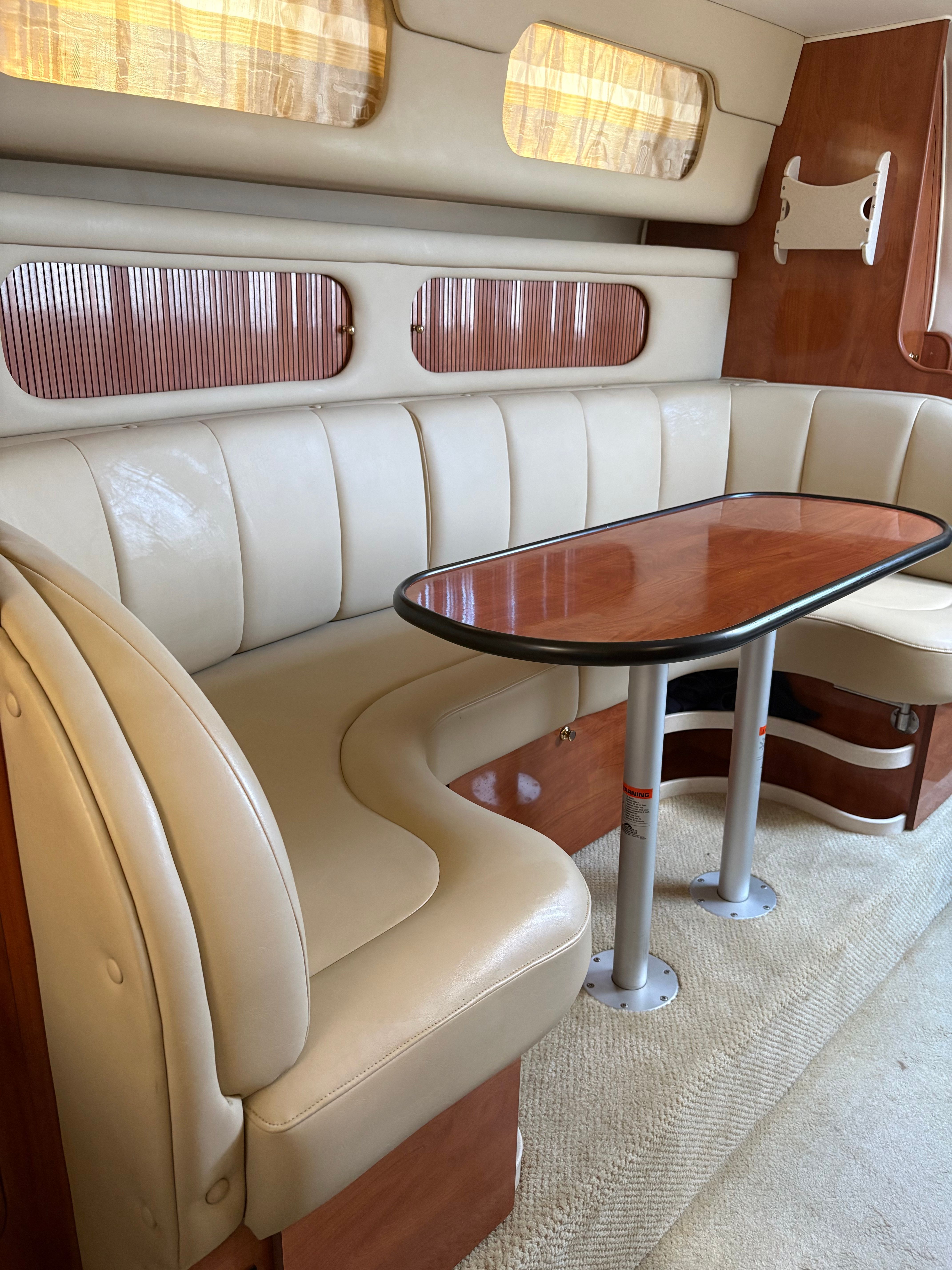Interior of 2002 Rinker Fiesta Vee 342 yacht with leather seating and wooden table.