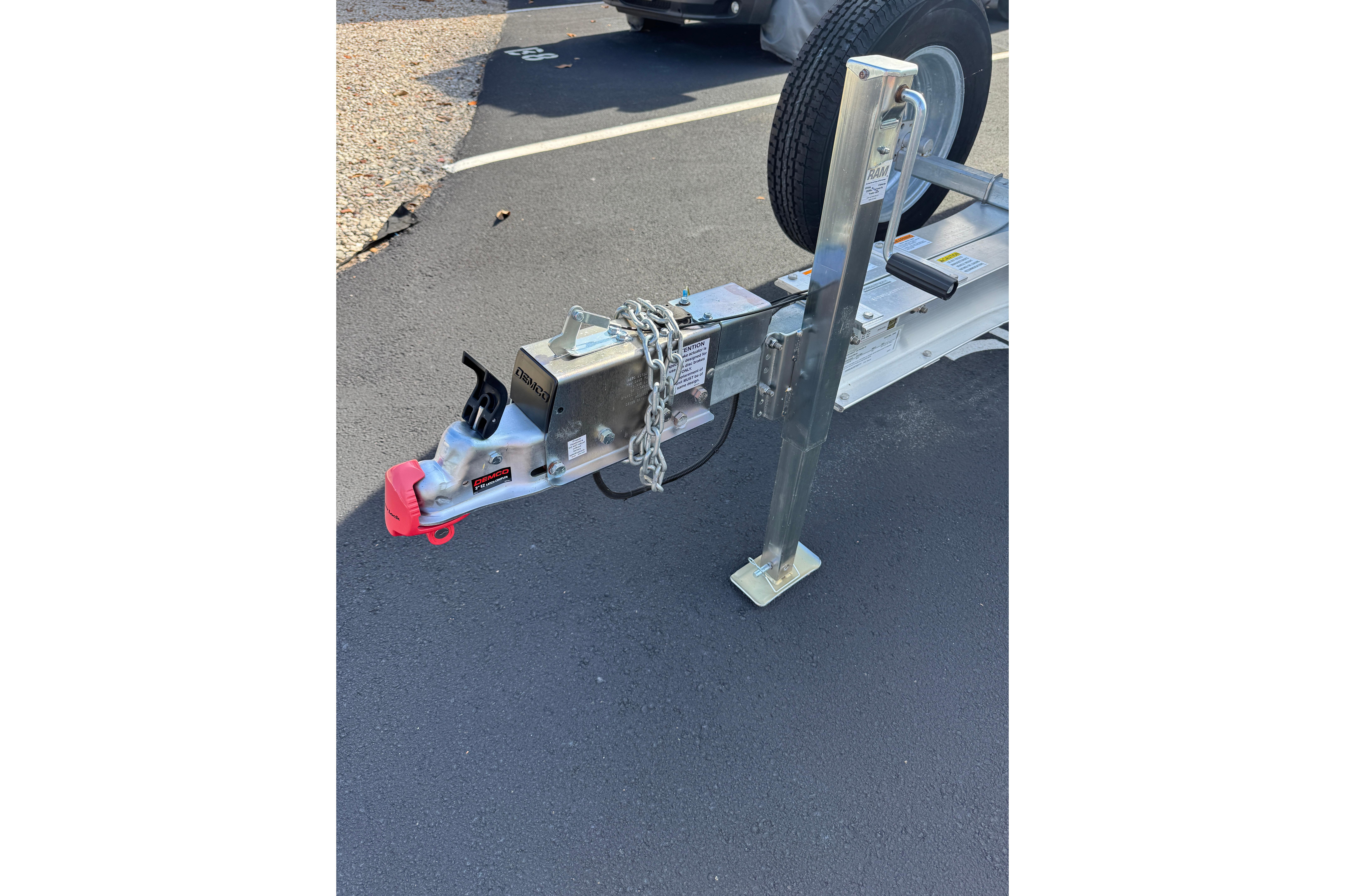 Trailer hitch and jack stand for 2018 Hurricane SunDeck 2400 OB boat on asphalt.