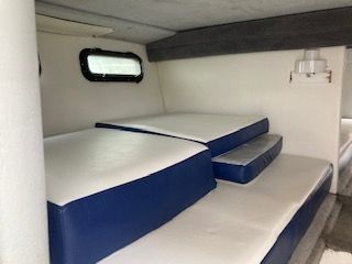 Interior of a boat with blue and white cushions.