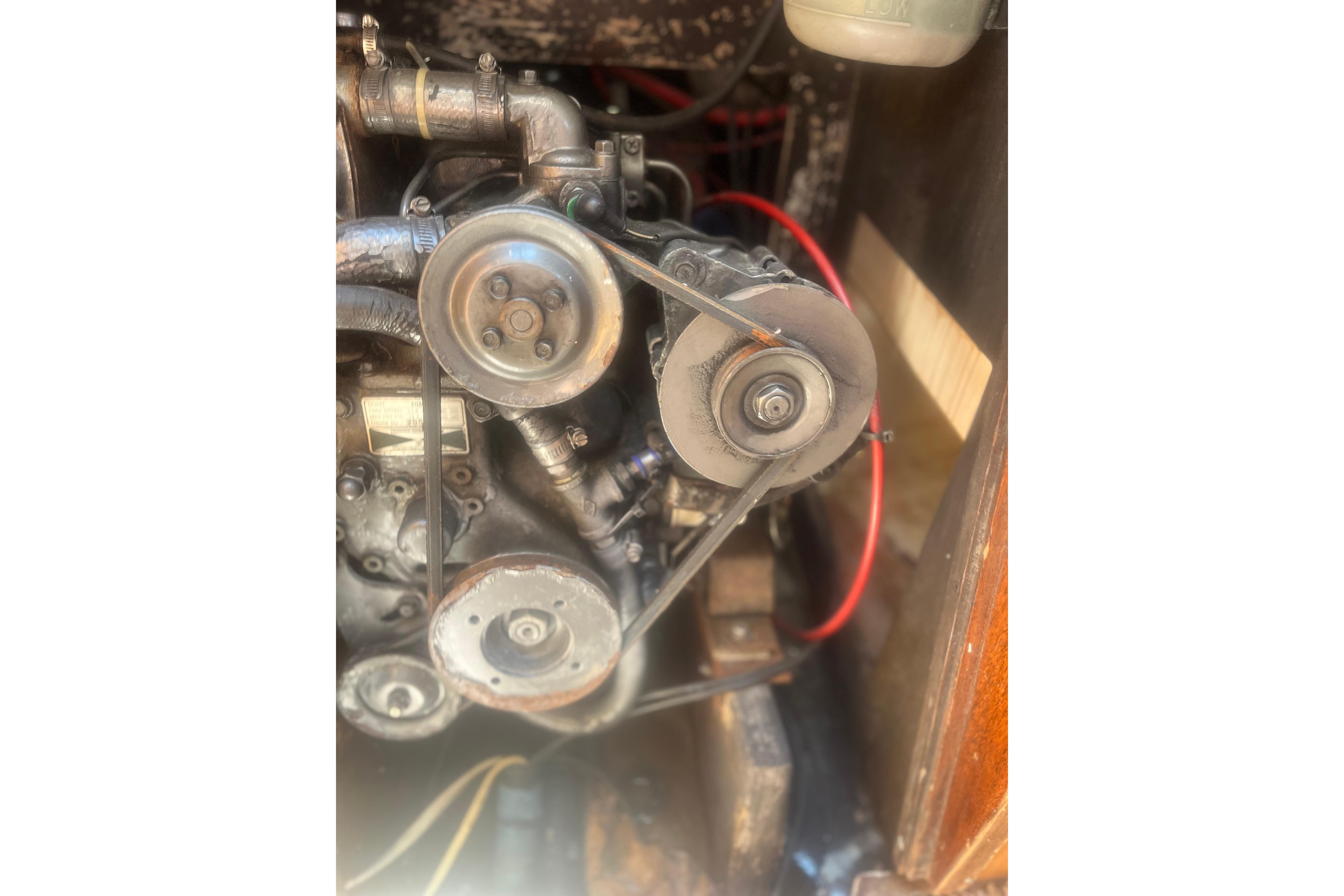 Engine components of a 1972 C&C 30 sailboat, featuring belts and pulleys.