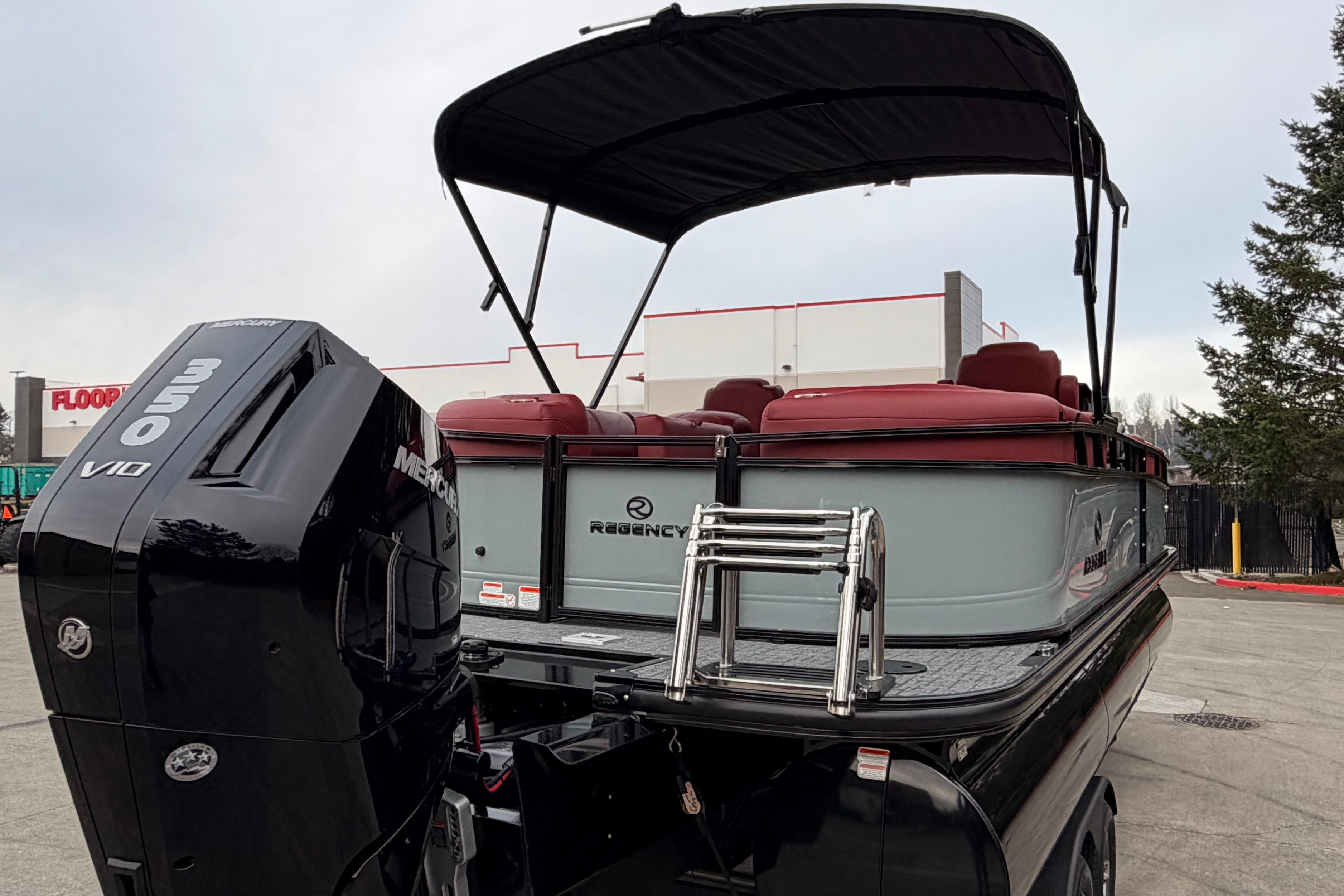 2026 Regency 250 DL pontoon boat with Mercury 350 V10 engine, docked outdoors.
