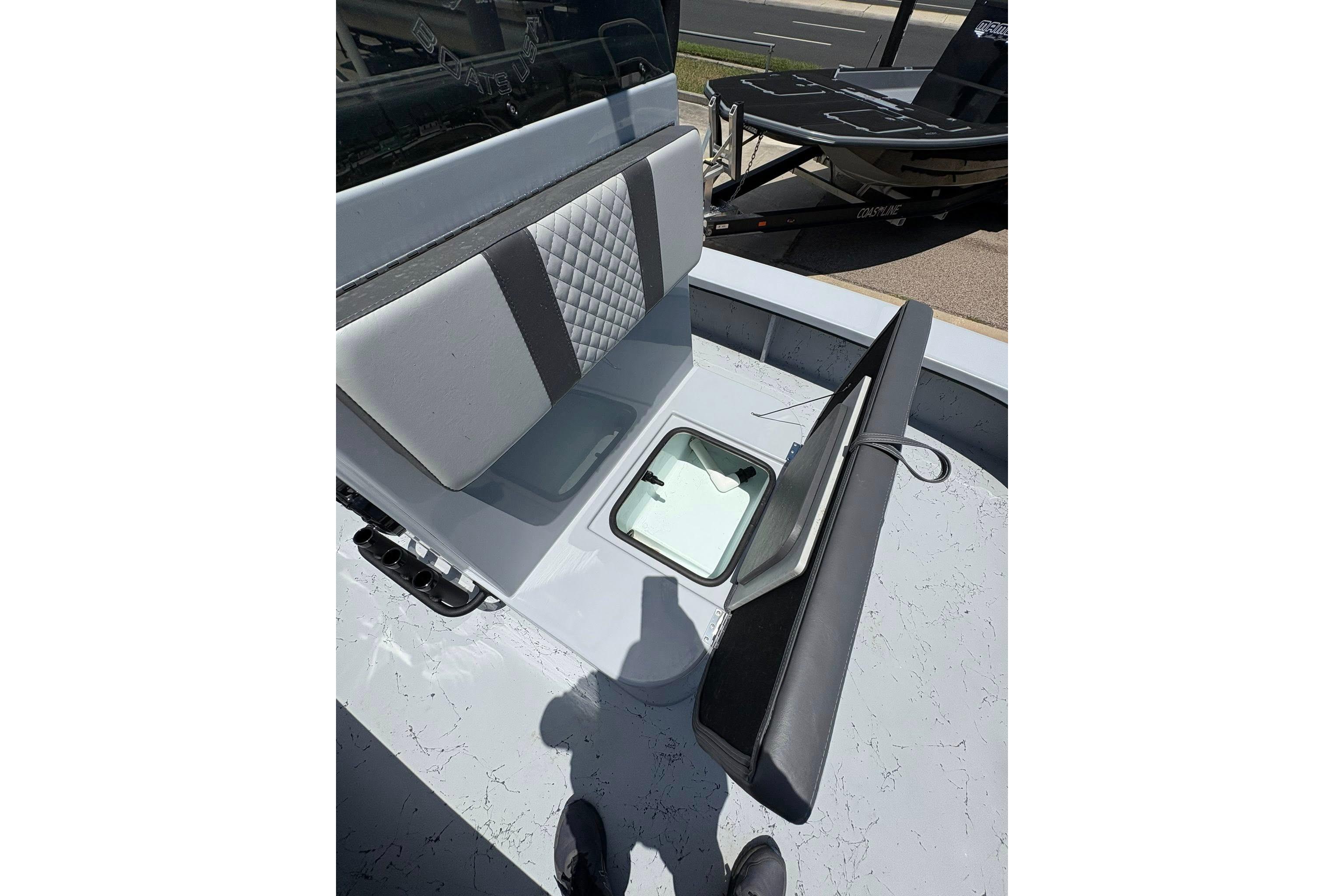 2026 Freedom Boats 23' Warrior interior with cushioned seating and storage compartment.