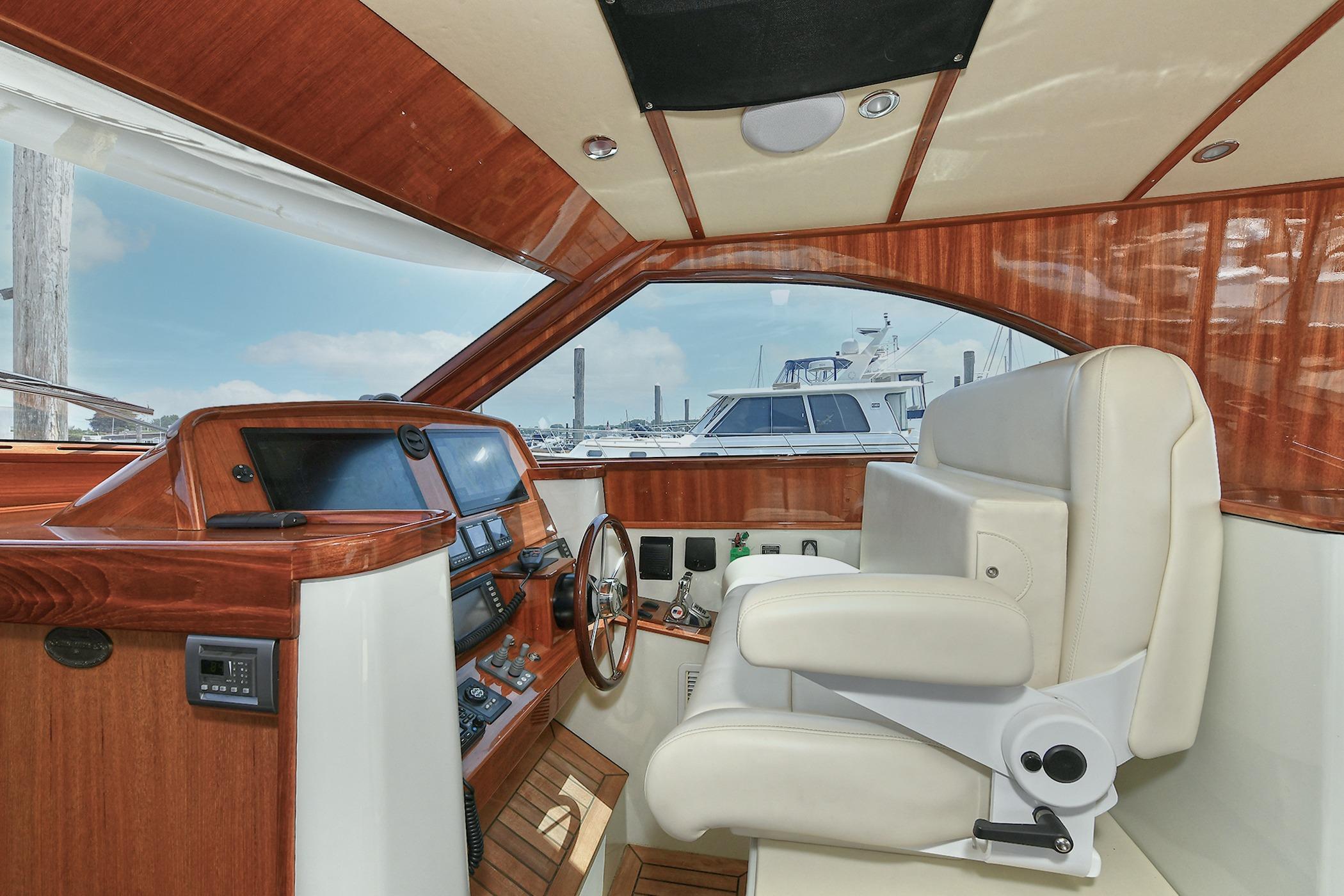 Luxurious 2005 San Juan Downeast Express yacht interior with wooden dashboard and plush seating.
