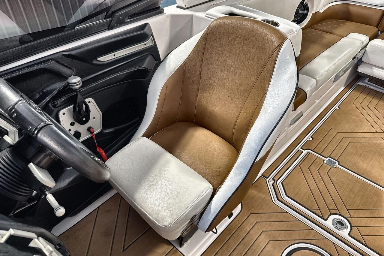 2020 Supra SE boat interior with brown and white seating, steering wheel, and modern dashboard.
