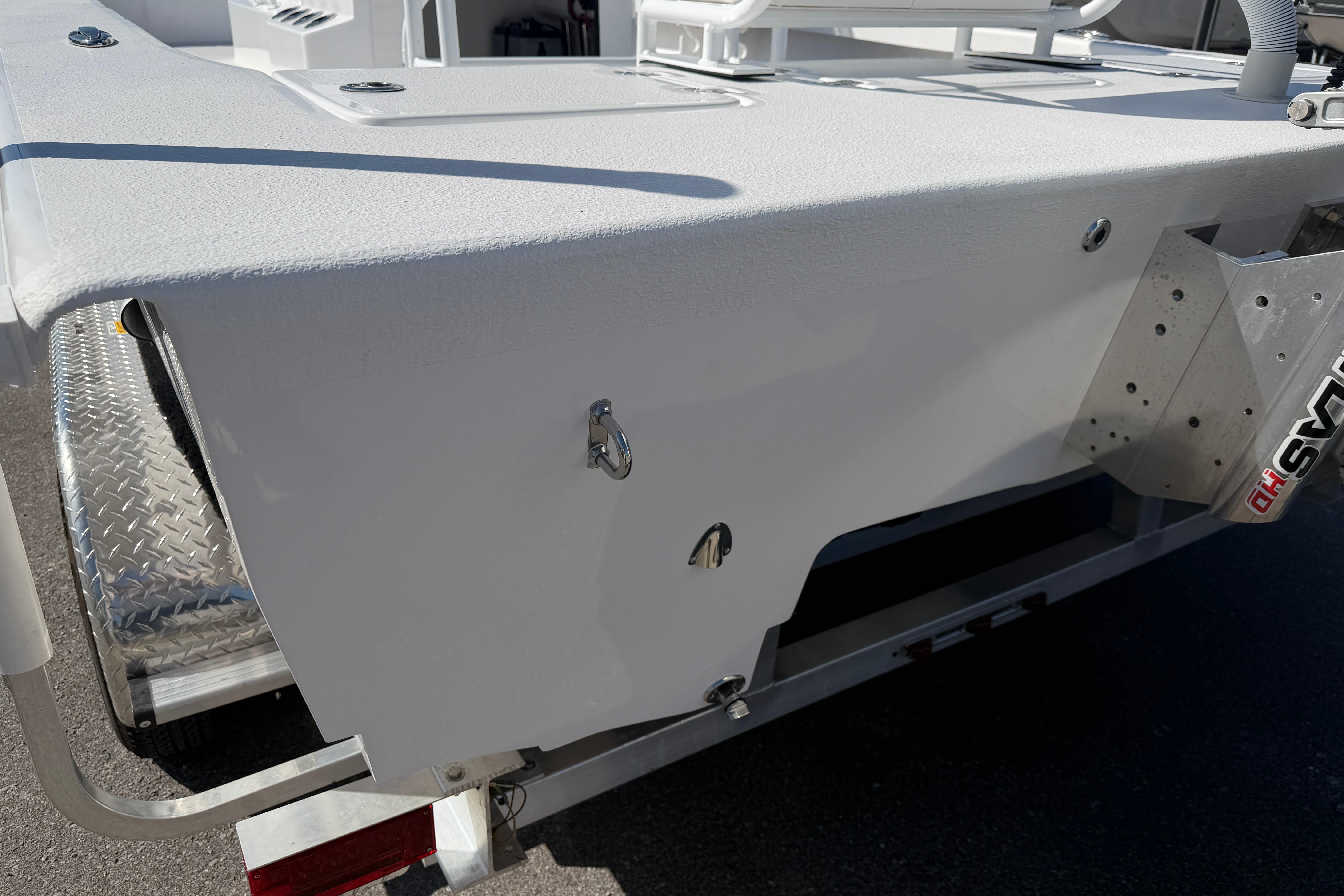 2026 Skuta 24 Cat boat rear view with metal fixtures and trailer.
