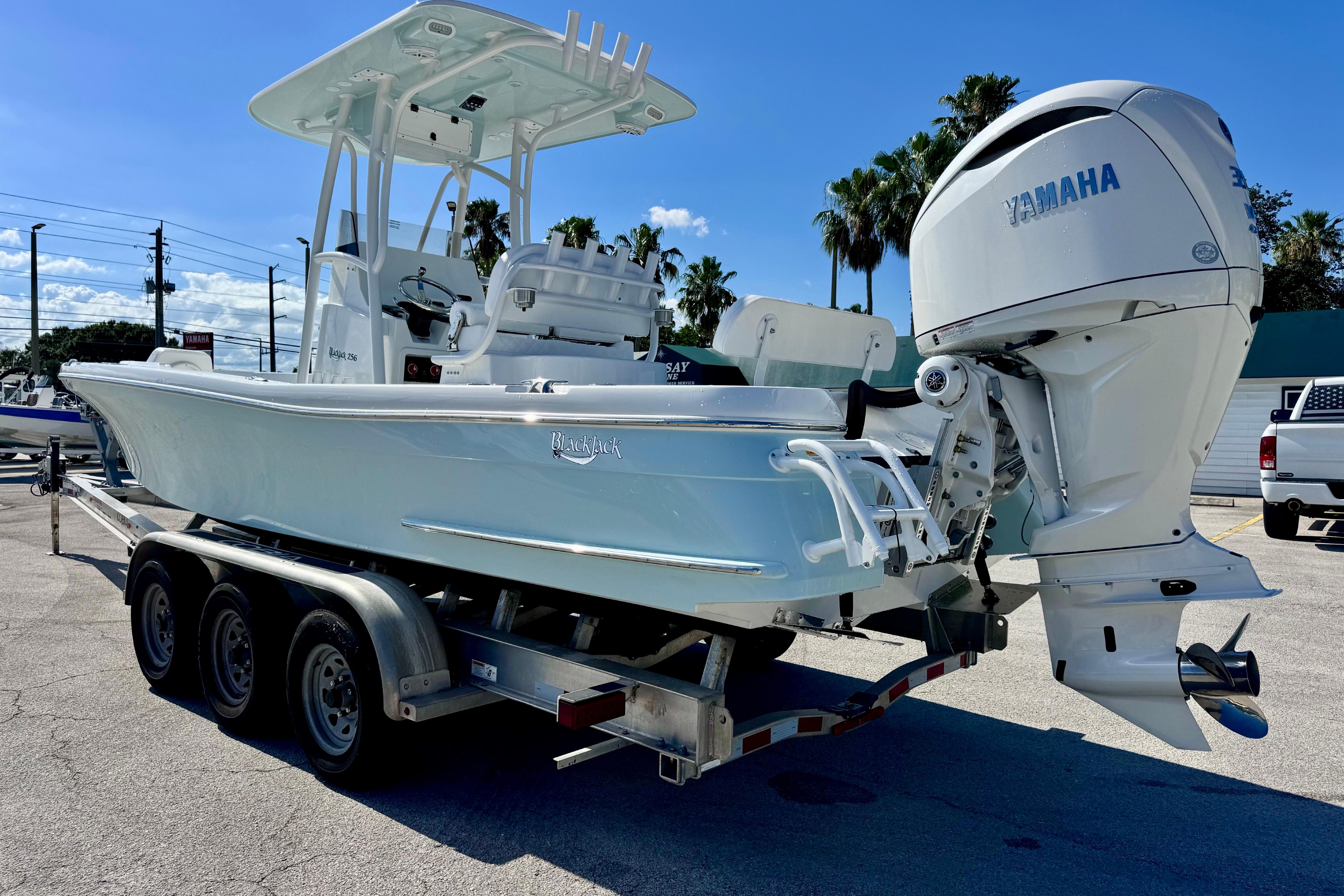 2026 BlackJack 256 Coastal boat on trailer with Yamaha engine, parked outdoors.