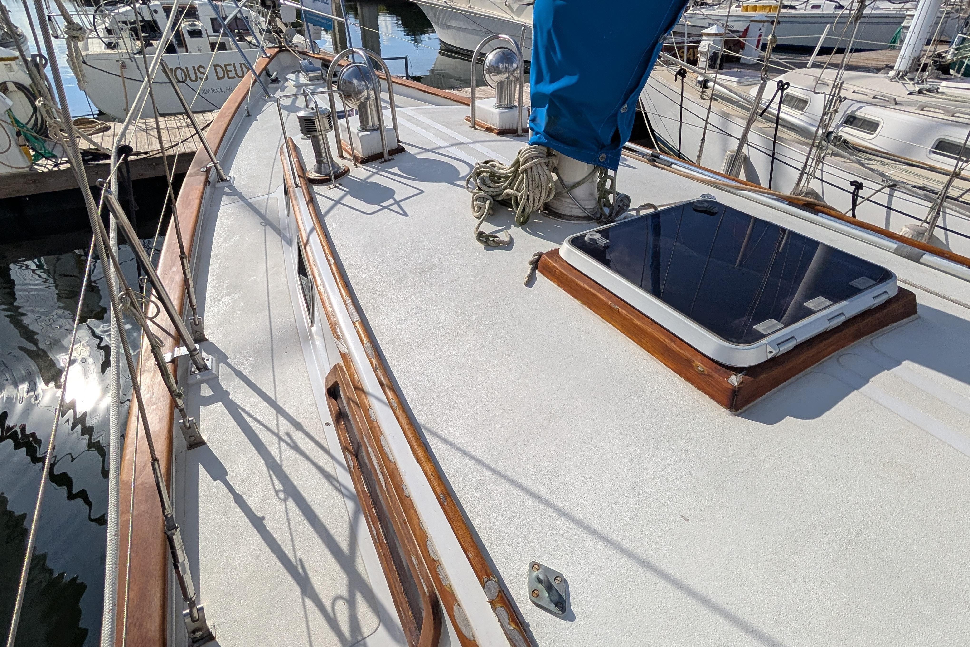 Deck of a 1983 Robert Perry 41 sailboat with winches and hatch.